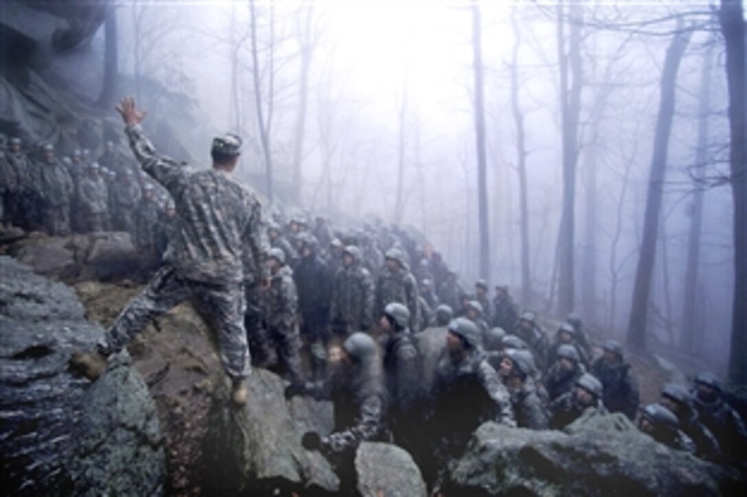A U.S. Army Ranger instructor explains the technical instructions of repelling from the 50-foot rock to his left in Dahlonega, Ga., April 13, 2009. It is one of three phases of training.