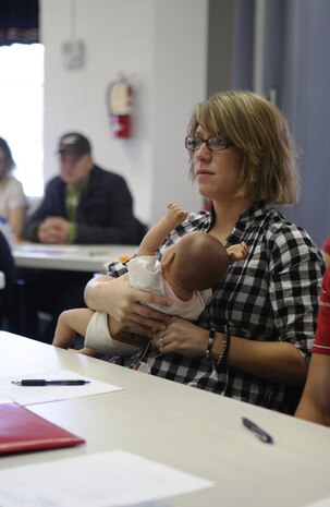 Lance Cpl. Hether Zeckser, with 2nd Supply Battalion, Combat Logistics Regiment 25, 2nd Marine Logistics Group, holds the "crying baby" doll as the instructor during the Mom's Basic Training and Daddy's Baby Boot Camp course, discusses the different things to look for when an infant is crying. The free two-day course is held by the New Parent Support Program on base, and is open to all military members and their spouses with young children and new and expecting parents.