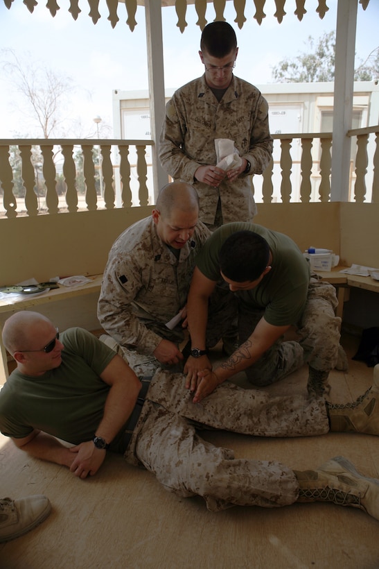 Private Juan Gonzalez, the Gunner’s assistant with Headquarters Company, Regimental Combat Team 8 is instructed on how to place a tourniquet by combat lifesavers course instructors at the Regimental Aid Station, Camp Ripper, Iraq. The course taught Marines how to use tourniquets, pressure dressings and how to assess casualties in combat.