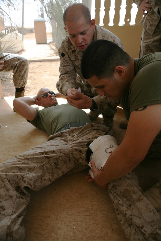 Private Juan Gonzalez, the gunner’s assistant with Headquarters Company, Regimental Combat Team 8, places a pressure dressing on a simulated casualty during a combat lifesavers course on April 16, 2009, at the regimental aid station, Camp Ripper, Iraq. The course taught Marines how to use tourniquets, pressure dressings and how to assess casualties in combat.