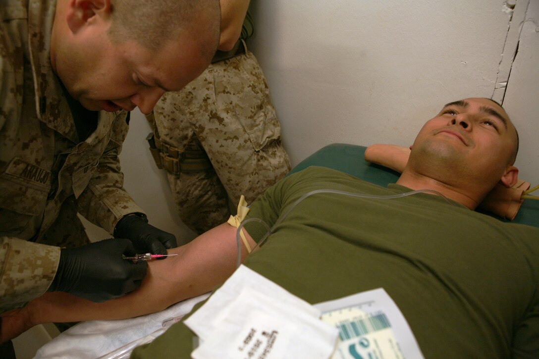 Seaman Wilson Araujo, a hospital corpsman with Regimental Aid Station, Regimental Combat Team 8, places an intravenous drip into 1st. Lt. Christopher Tamayo, the information management officer for Headquarters Company, Regimental Combat Team 8 during a combat lifesavers course on April 16, 2009, held at the regimental aid station , Camp Ripper, Iraq. Marines were taught how to place an IV into a casualty’s arm if corpsmen weren’t available.