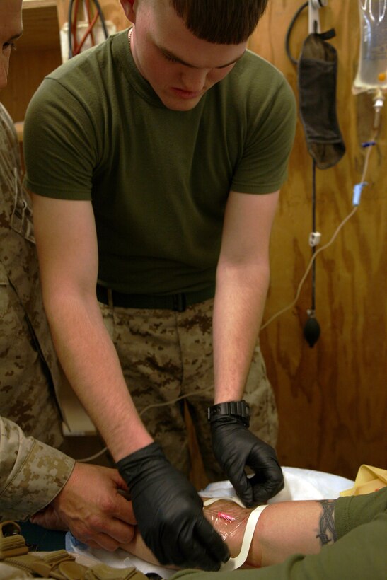 Corporal Philip Dorman, a fires watch clerk with Headquarters Company, Regimental Combat Team 8, applies a self-adhesive to protect the intravenous drip from infection during a combat lifesavers course held at the regimental aid station on April 16, 2009, at Camp Ripper, Iraq. Dorman made sure to try every technique taught during the course because, “now I know exactly how to perform these lifesaving procedures on my buddy in combat.”