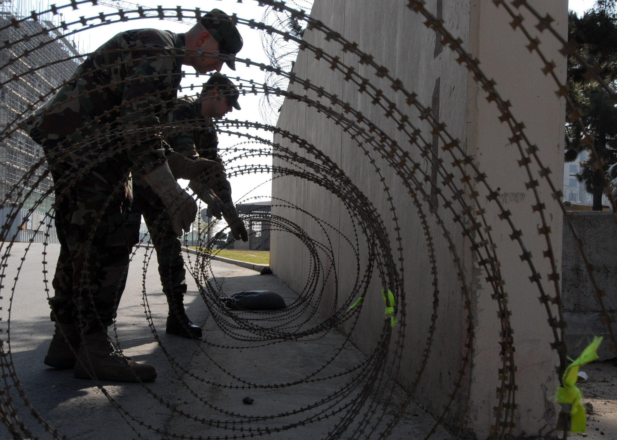 Senior Airman Russell Delaney and Staff Sgt. Joel Lanning, 8th Communications Squadron, carefully set up concertina wire in anticipation of the Operational Readiness Inspection at Kunsan Air Base, Republic of Korea, April 17. Wolf Pack Airmen, Soldiers and civilians have completed multiple, rigorous exercises to prepare for this important inspection. (U.S. Air Force Photo/SrA Gustavo Gonzalez)