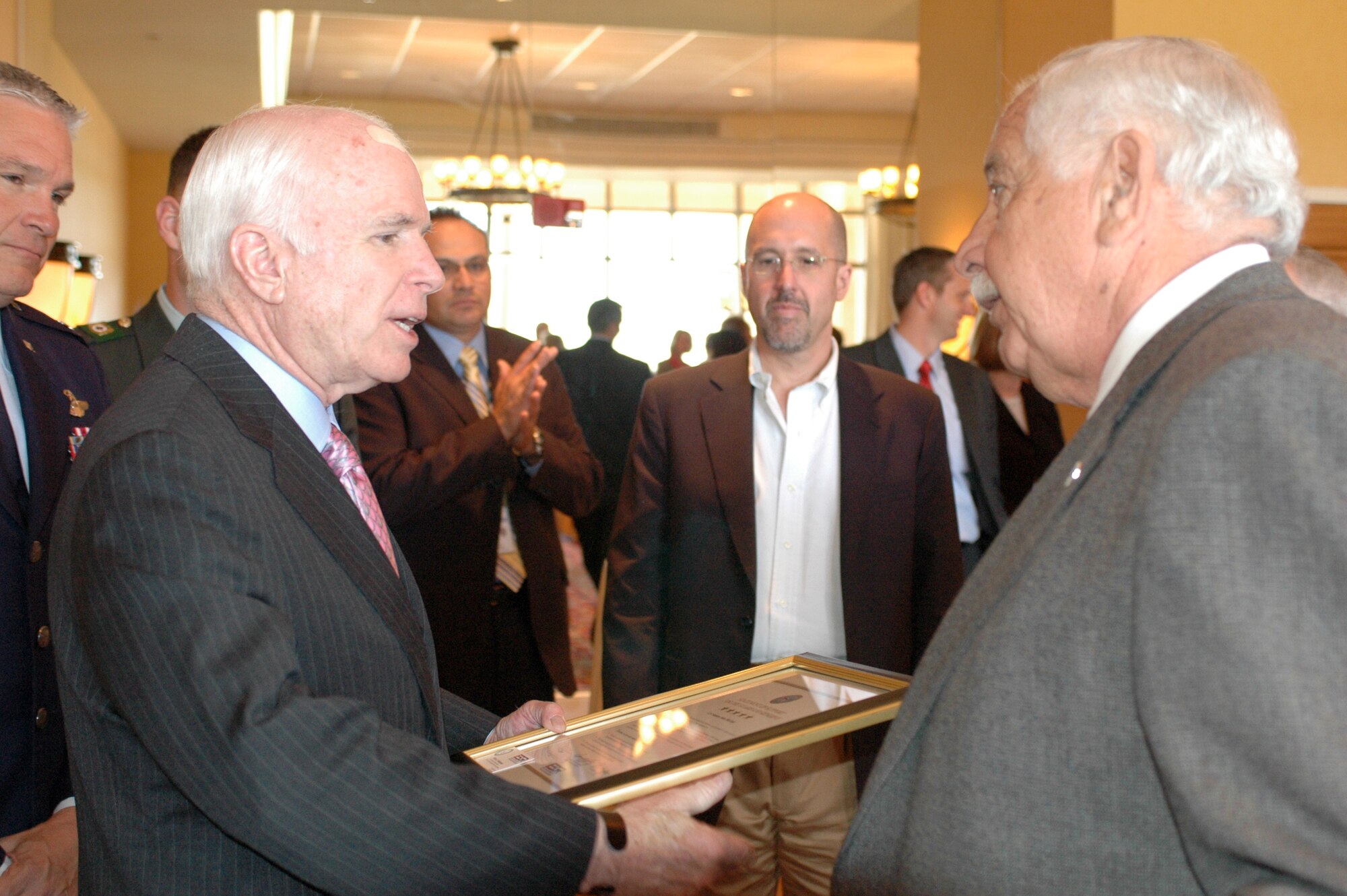 Bill Valenzuela presents a framed ESGR certificate of support to U.S. Senator John McCain April 16. Valenzuela is a veteran of the Korean War having served in the U.S. Marine Corps Reserve. Today he continues to serve the military as Arizona State Chair Emeritus for the National Committee of Employer Support of the Guard and Reserve. Through ESGR, he promotes understanding and support between employers and their National Guard and Reserve member employees. (Air National Guard photo by Capt. Gabe Johnson)