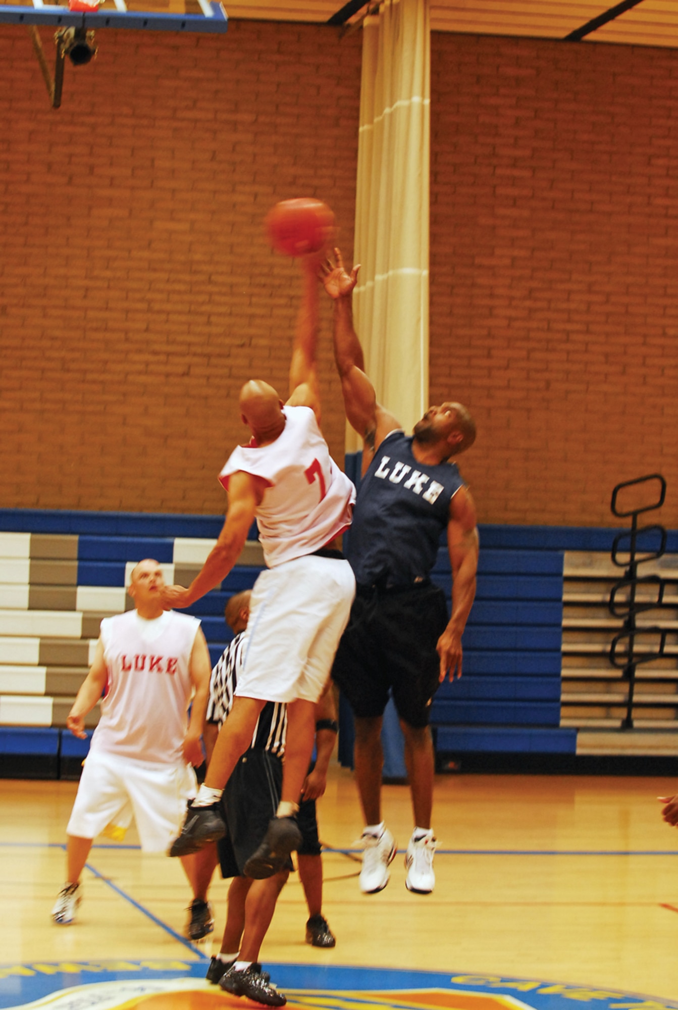 DeRon Hudson, left, 56th Maintenance Operations Squadron, goes after the tip-off against Elton Vance, 56th Civil Engineer Squadron in the 2009 winter over-30 basketball championship game. MOS won 43-40. (U.S. Air Force photo/ Kevin Bruaw)