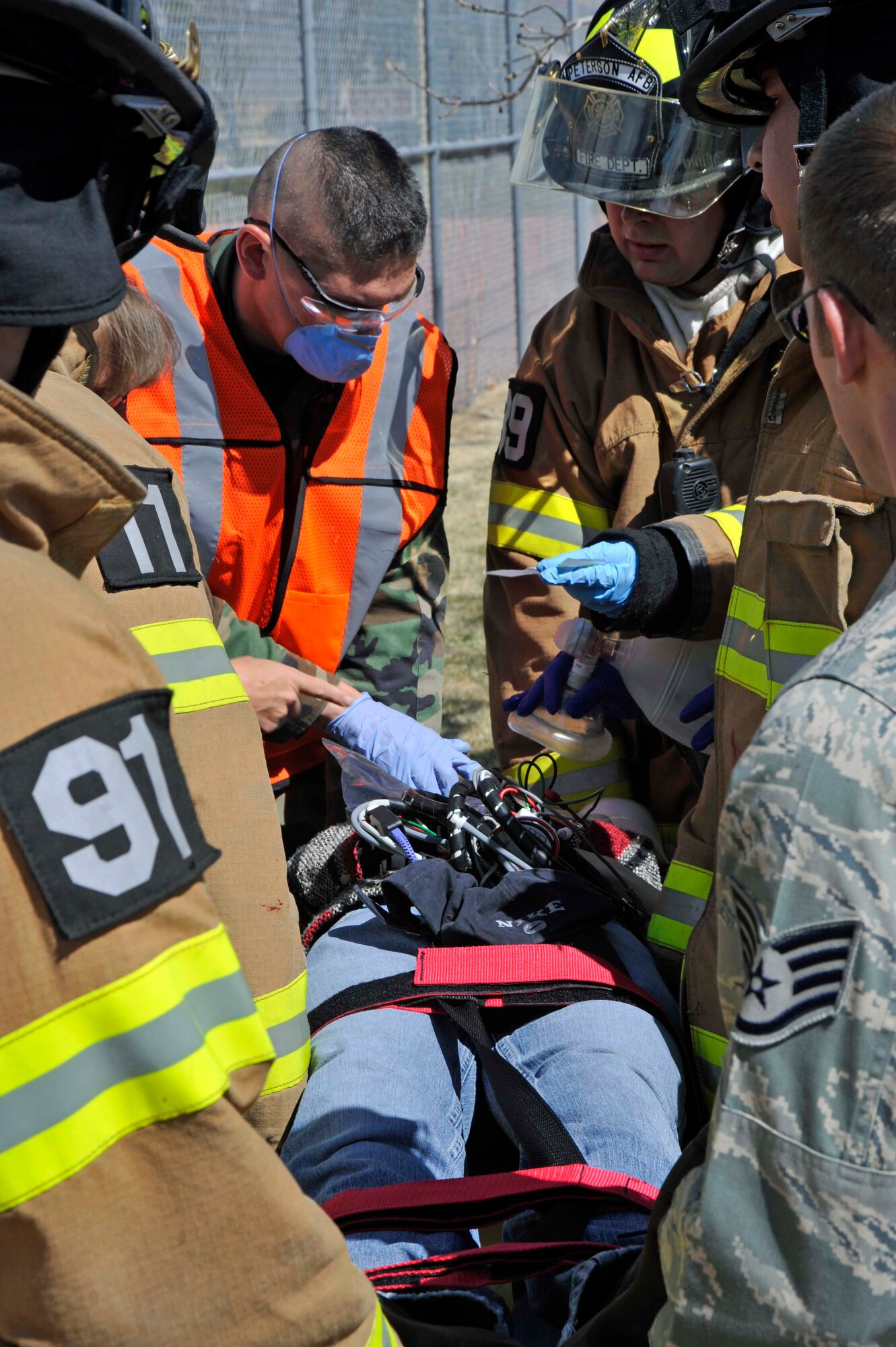 Peterson medics respond to aid simulated injured from a tornado scenario during Wednesday’s emergency management exercise.  The ORI graded event showcased the wing’s response to a natural disaster exercise featuring mock mass casualties.  The exercise occupied a small corner of the base, but tested all emergency responders and command and control aspects associated with installation support and protection. Adding to the realism, a civilian Flight-For-Life helicopter  based in Colorado Springs demonstrated the integral relationship the base has with its civilian counterparts. (U.S. Air Force photo)
