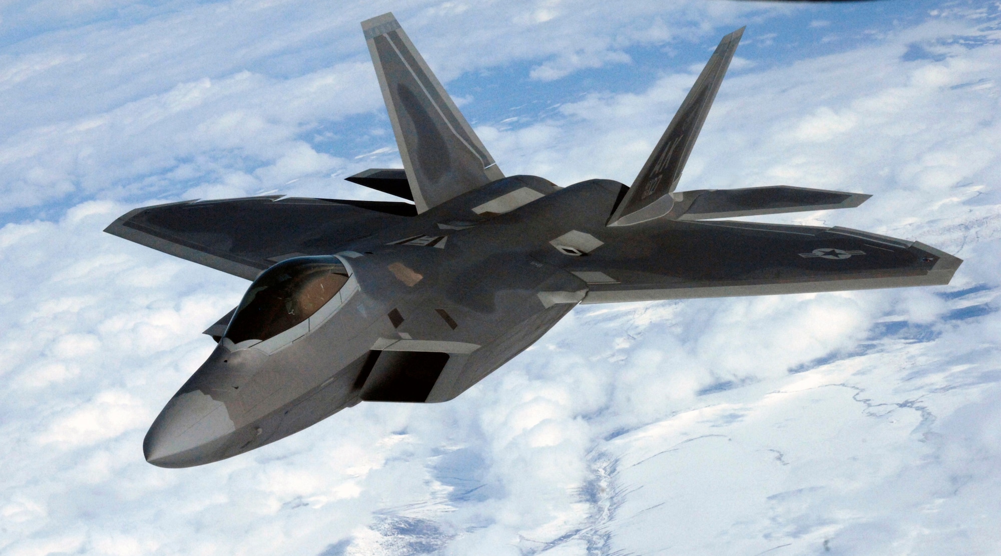 ELMENDORF AFB, Alaska -- An F-22 flies over the rocky terrain of Alaska during an in-flight refueling mission April 15, 2009. The F-22 was in a group of fighters being refueled by a KC-135 air refueler. (U.S. Air Force photo by Senior Airman Laura Turner) (RELEASED)
