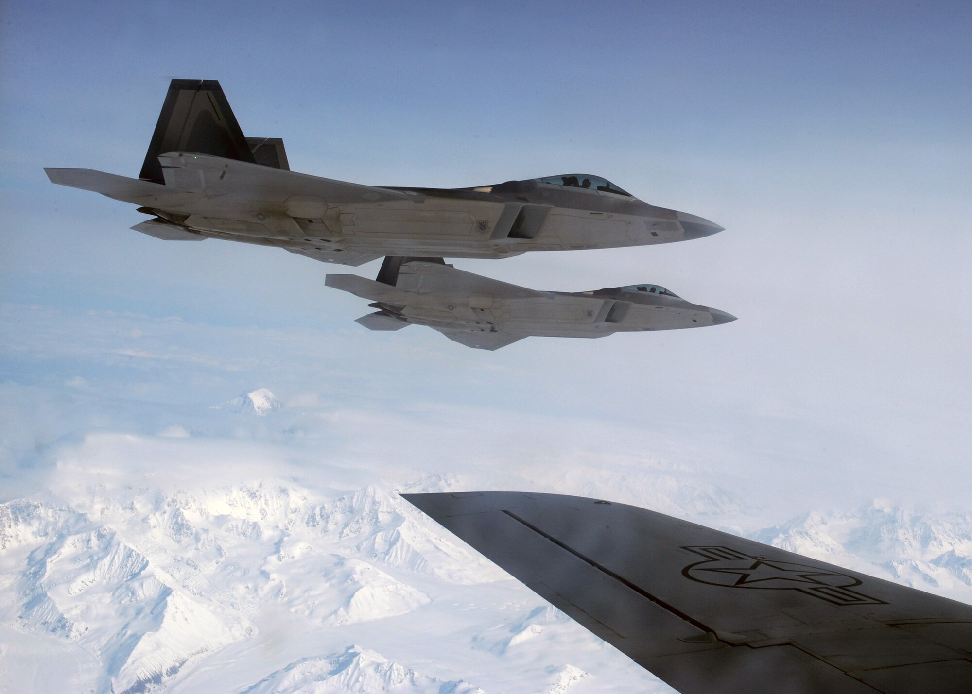 ELMENDORF AFB, Alaska -- Two F-22 Raptors fly wing to wing with a KC-135 aircraft refueler during a mission April 15, 2009. These Raptors were successfully refueled during flight and returned safely home to Elmendorf. (U.S. Air Force photo by Senior Airman Laura Turner) (RELEASED)