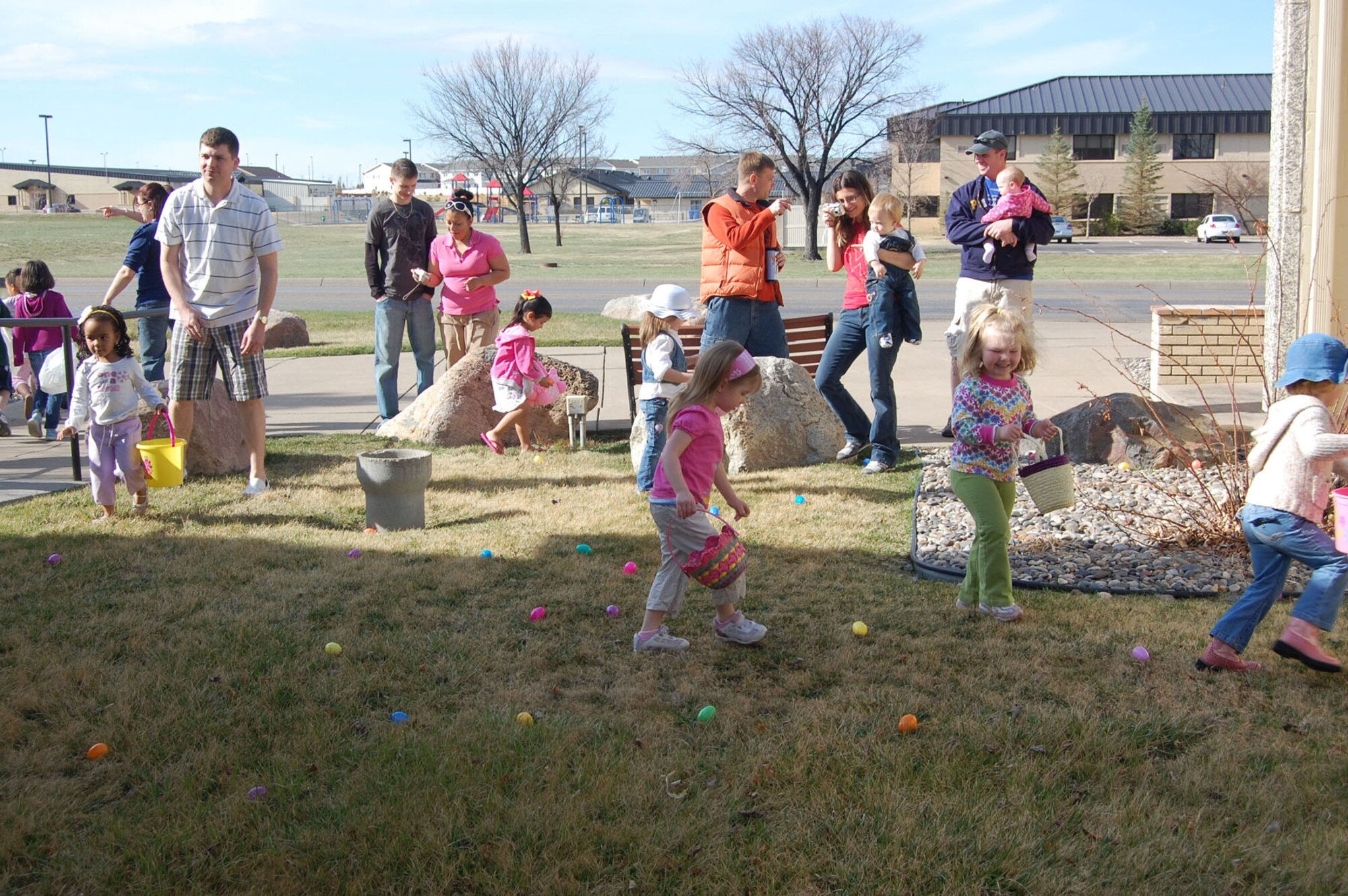 A group of 3- to 4-year-olds scour the grounds for Easter eggs outside the base chapel April 11. More than 30 children searched the chapel grounds for more than 500 plastic eggs filled with candies and Bible verses. The Easter egg hunt is an annual event hosted by the 341st Missile Wing chapel staff. (U.S. Air Force photo/Staff Sgt. Eydie Sakura)