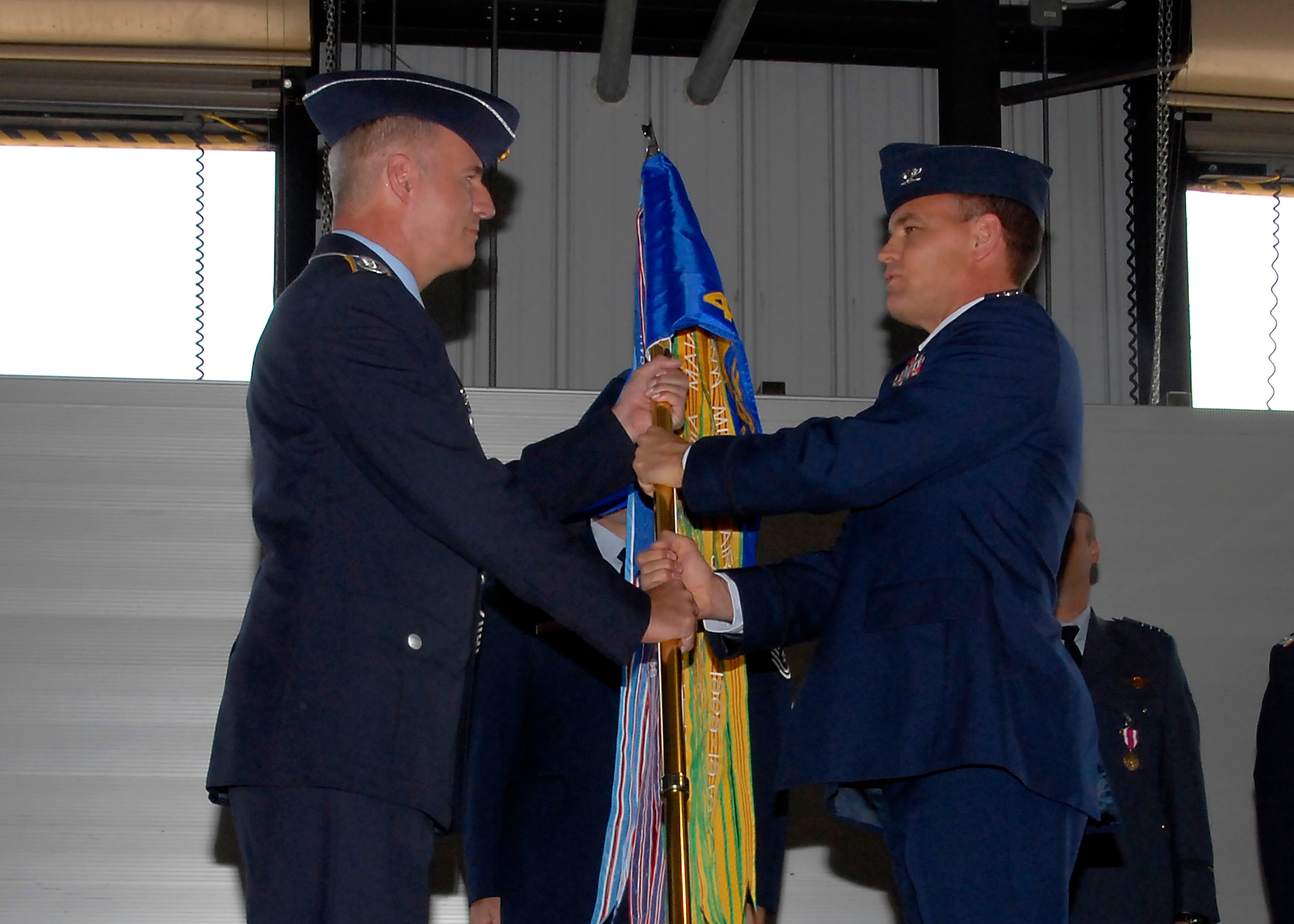 German air force Col. Axel Pohlmann, 80th Operations Group commander, passes the squadron guidon to Lt. Col. Richard Griffin, the first commander of the 469th Flying Training Squadron, at the 469th FTS reactivation ceremony April 10. The squadron was reactivated to alleviate congestion in the 90th FTS. (U.S. Air Force photo/Mike Litteken)