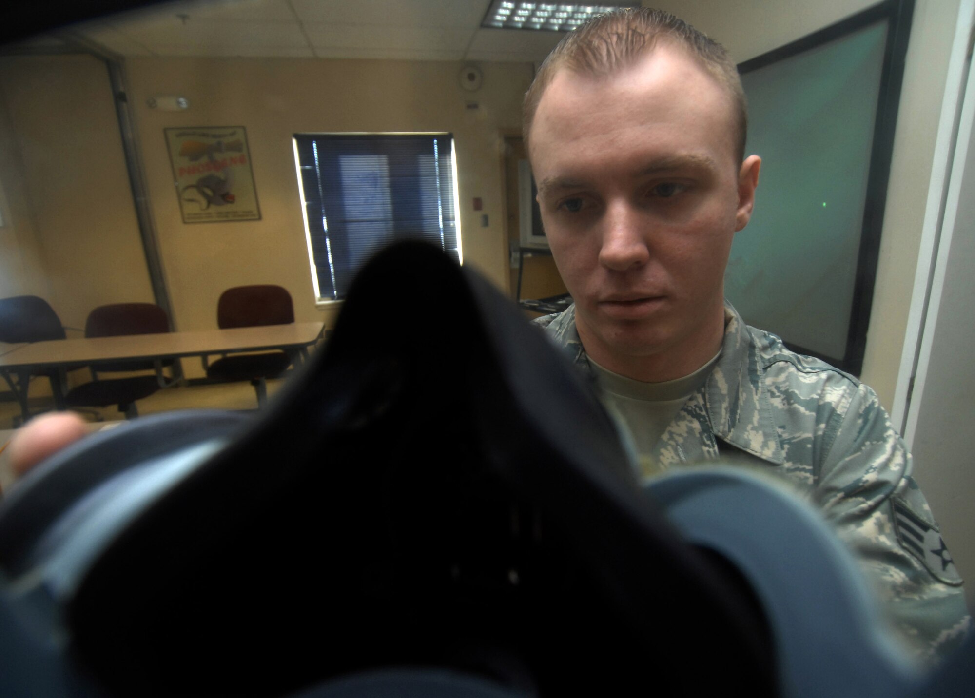 Senior Airman John Buckley inspects a gas mask for cracks and misuse April 7. Airman Buckley is a chemical, biological, radiological, nuclear and high-yield explosives training instructor and responder assigned to the 354th Civil Engineering Squadron at Eielson Air Force Base, Alaska. (U.S. Air Force photo/Senior Airman Christopher Boitz)