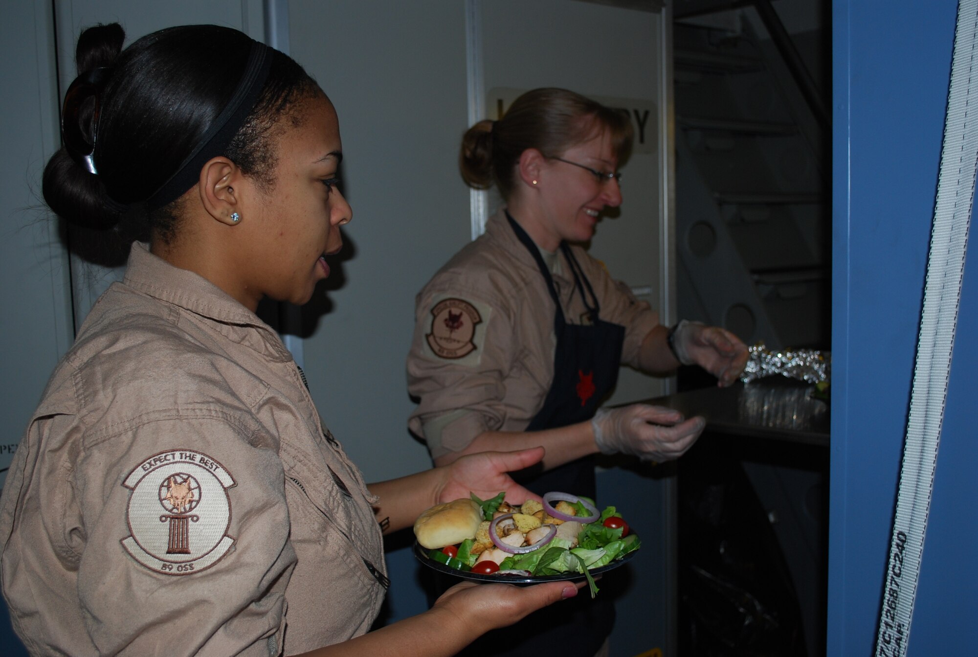 Staff Sgt. Jamiliah Austin-Graves and Tech. Sgt. Jennifer Lindner, 89th Airlift Wing, Operations Support Squadron, Andrews AFB, D.C., work together to keep the Air Force's special passengers well fed and comfortable over places like Iraq and Afghanistan. (Air Force photo/ MajorBill Walsh)