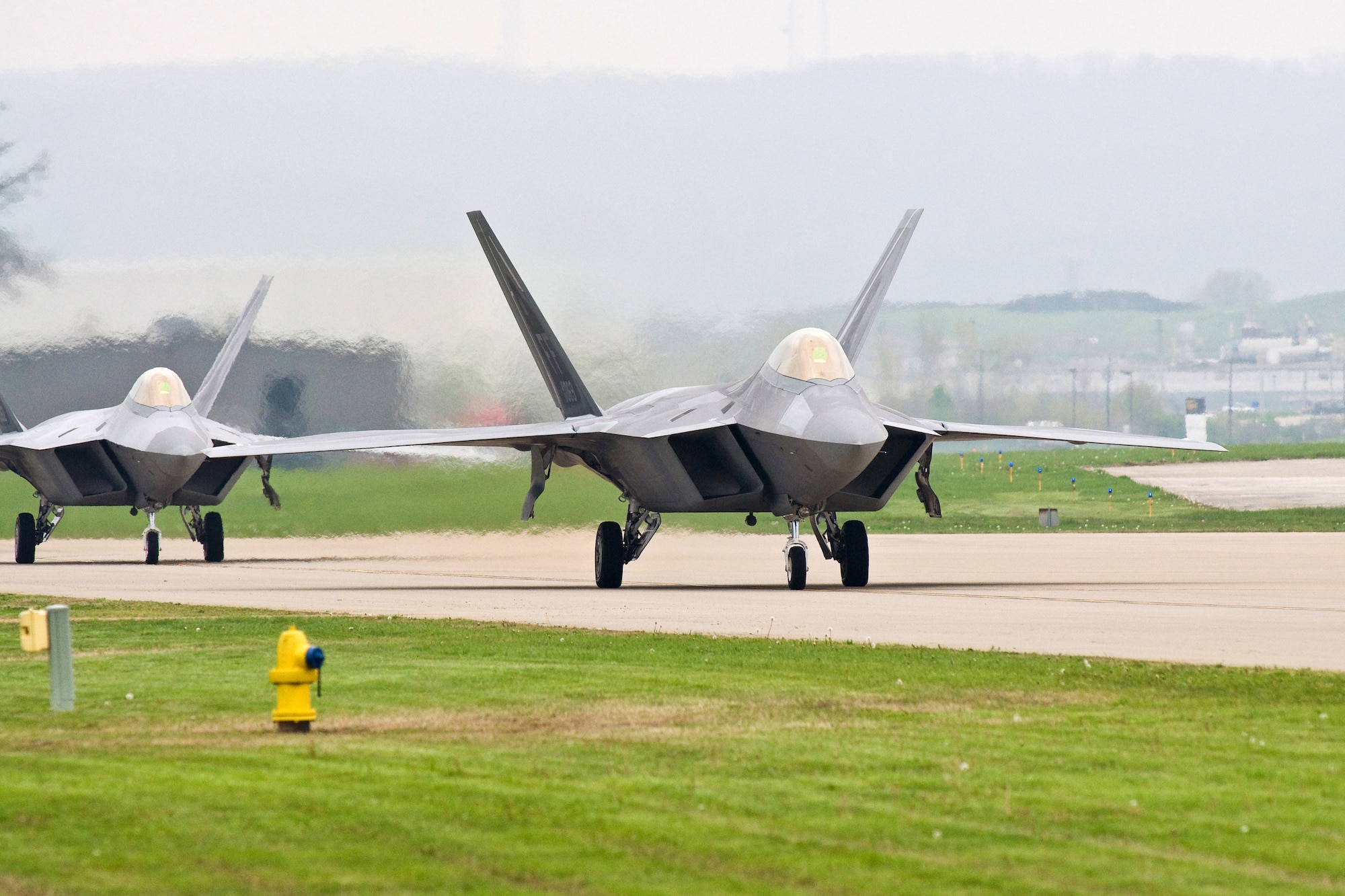 Two Air Force F-22 Raptors taxi on the flightline of the Kentucky Air National Guard Base in Louisville, Ky., April 16. The aircraft are assigned to the USAF Raptor Aerial Demonstration Team at Langley Air Force Base, Va., and will participate in the Thunder Over Louisville Airshow on April 18. (USAF photo by Capt. Dale Greer.)