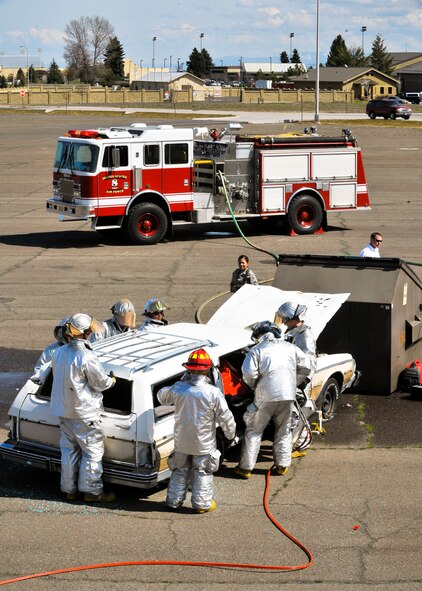 92nd Civil Engineer Squadron fire teams prepare to remove the roof of an automobile after a simulated car crash April 13. (U.S. Air Force photo / Senior Airman Joshua K. Chapman)