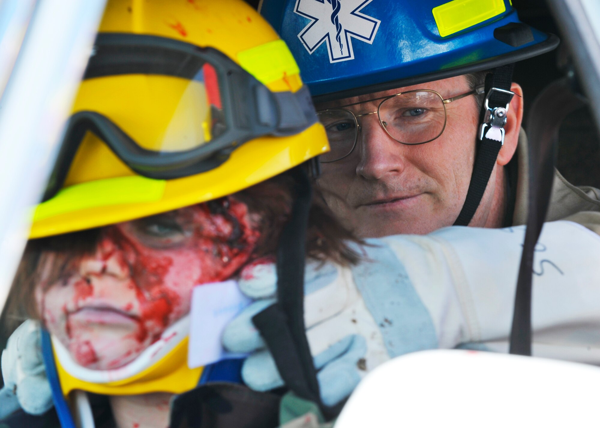 Col. Robert Thomas, 92nd Air Refueling Wing commander, sustains Airman 1st Class Erica Spencer's neck, 92nd Medical Operations Squadron, after a simulated near-fatal accident takes place in a 141st ARW parking lot April 13. (U.S. Air Force photo / Senior Airman Joshua K. Chapman)