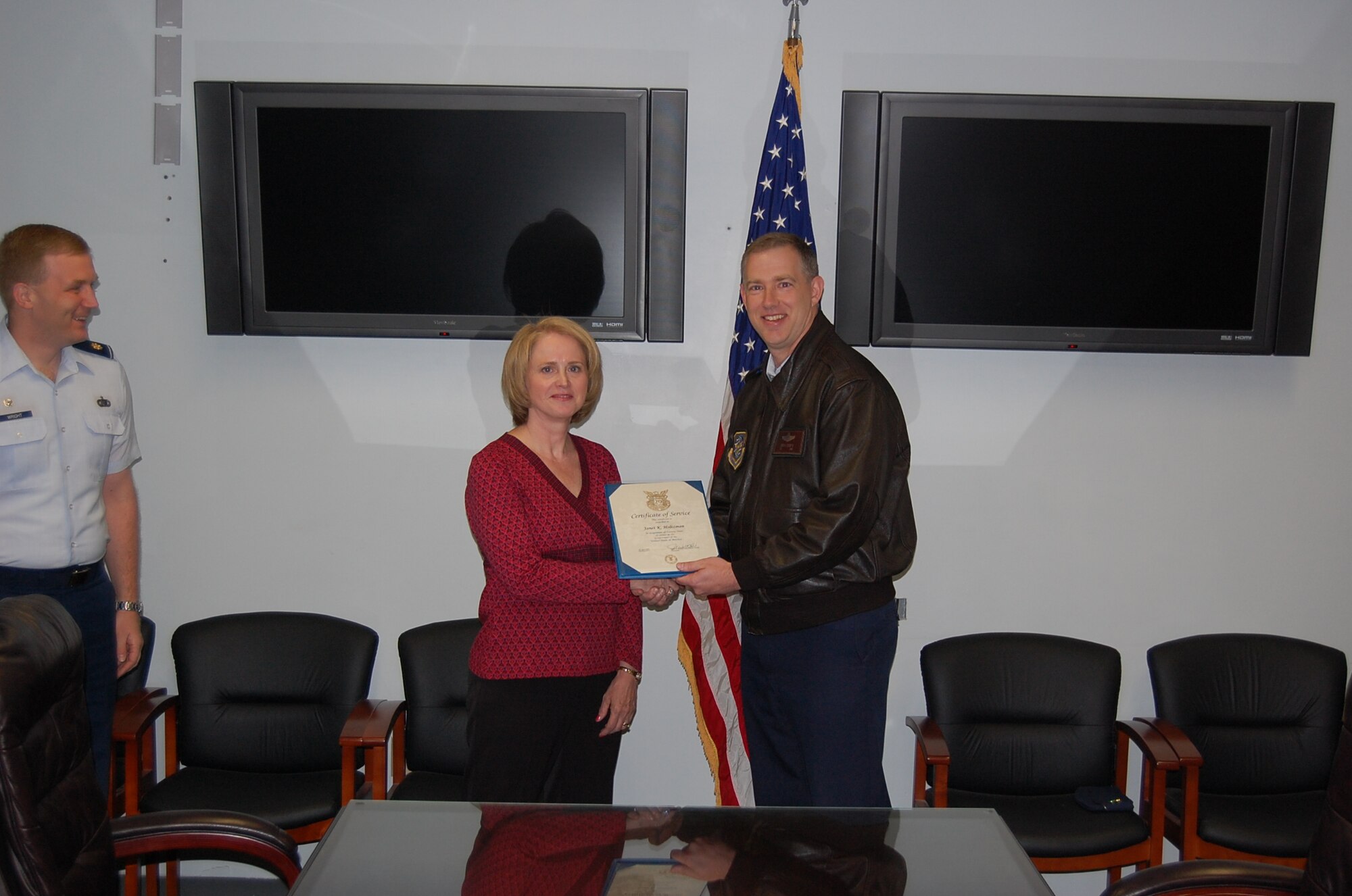 Col. John Gordy, 43rd Airlift Wing Vice Commander, presents Janet Holtzman, 43rd Contracting Squadron, with a plaque commemorating her 20 years in Civil Service in the 43rd CONS Conference Room April 13. (U.S. Air Force Photo)