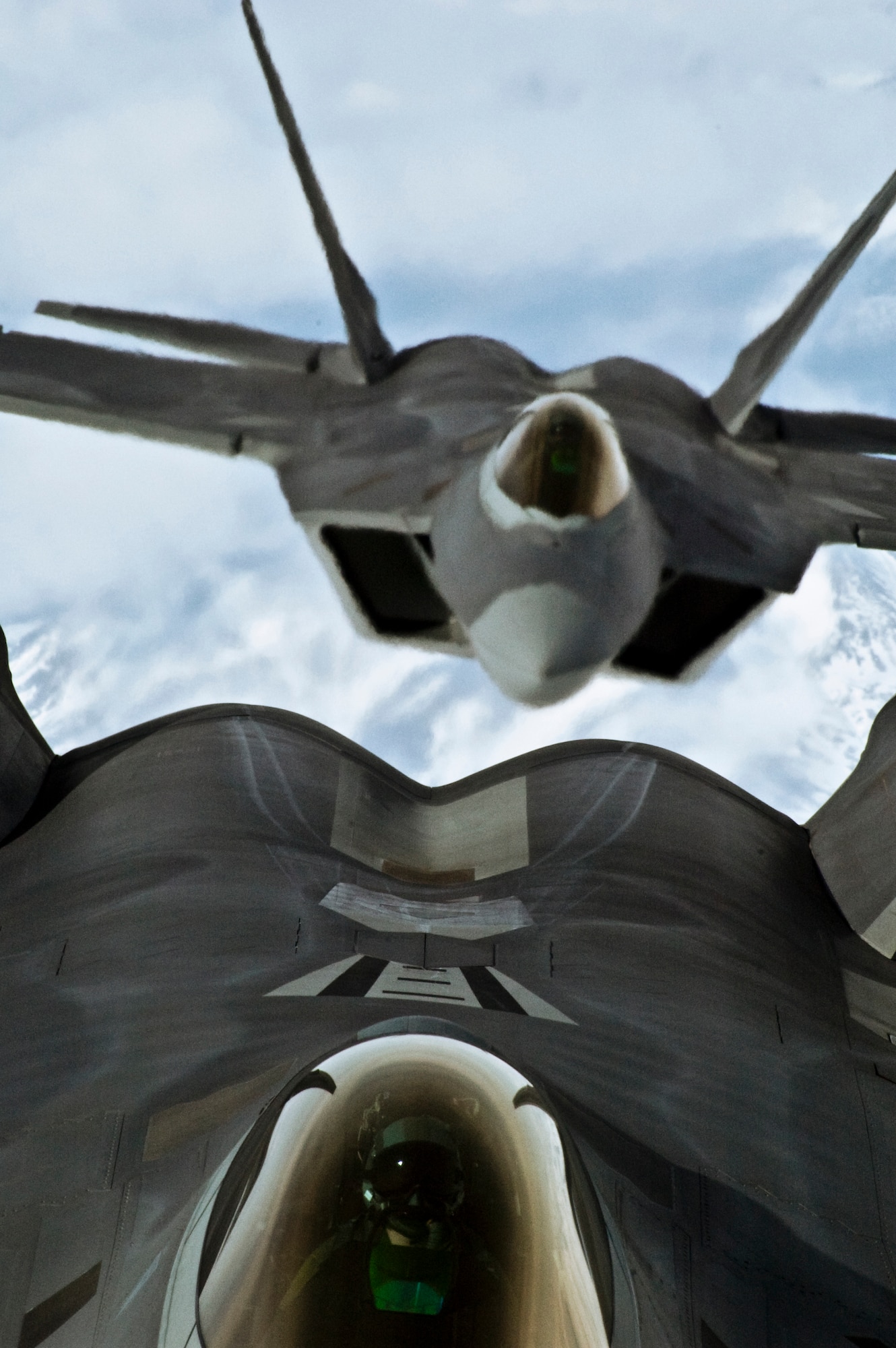 ELMENDORF AIR FORCE BASE, Alaska-- Two F-22s fly over Alaska's carved out mountain ranges as part of a refueling mission on April 15, 2009. The F-22s are 525th Fighter Squadron and are the Air Force's newest and stealthiest fighter aircraft. (U.S. Air Force photo by Airman 1st Class Christopher Gross)