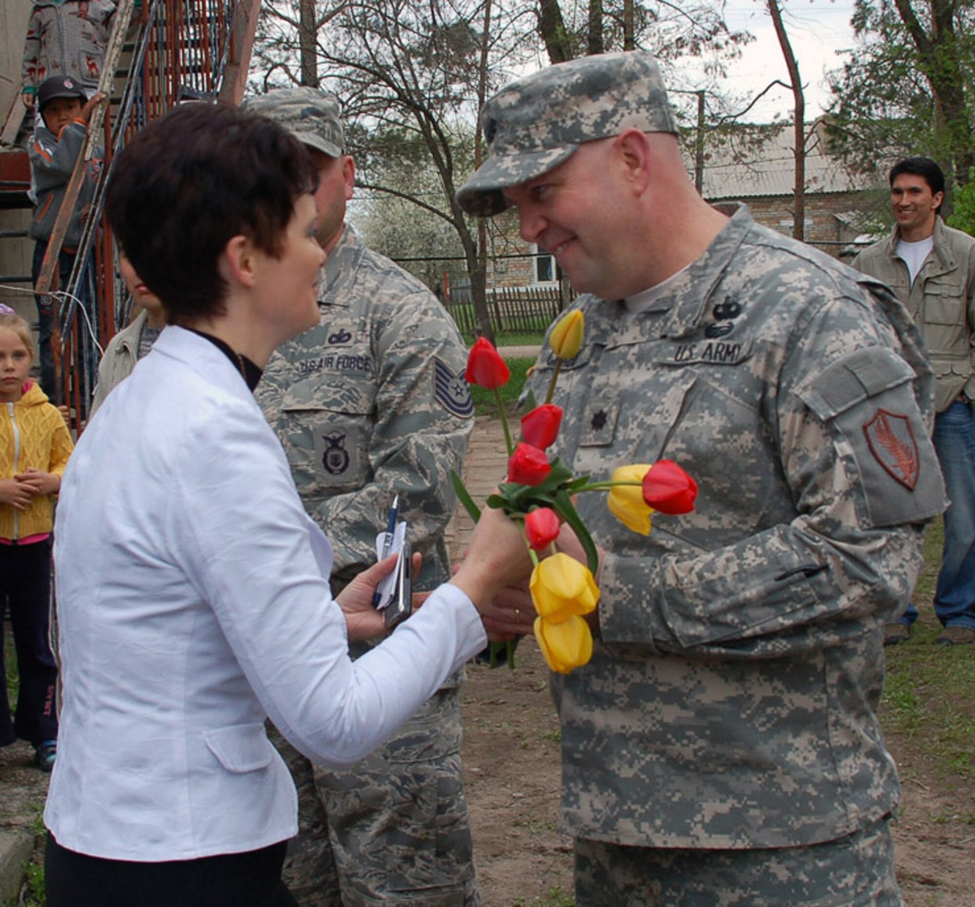 During a ground-breaking ceremony held April 14 for a renovation project at Birdik Village School in Kyrgyzstan, Olga Voroshihina, the school's principal, gives freshly picked tulips to Lt. Col. Patrick Crabb, chief of the U.S. Embassy's Office of Military Cooperation. The "thank you" was for his unwavering efforts over the past several years to secure funding for a $470,000 school renovation project. (U.S. Air Force photo/Tech. Sgt. Phyllis Hanson)
