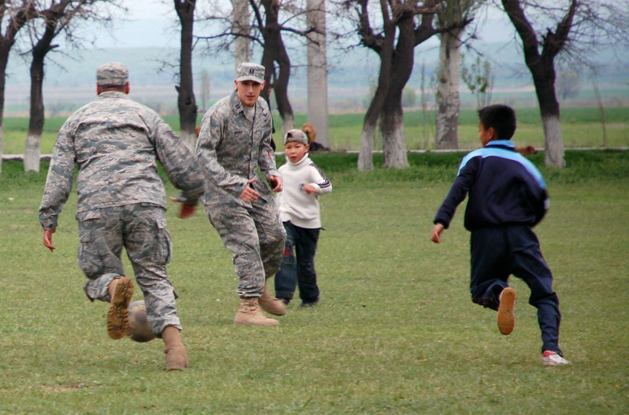 Following the symbolic ground-breaking ceremony April 14 at Birdik Village School in Kyrgyzstan, students from the school challenge Airmen from nearby Manas Air Base to an impromptu game of soccer. The Airmen were no match for the Kyrgyz children's agility and speed, and ended the game, 2-3. (U.S Air Force photo/Tech. Sgt. Phyllis Hanson)  