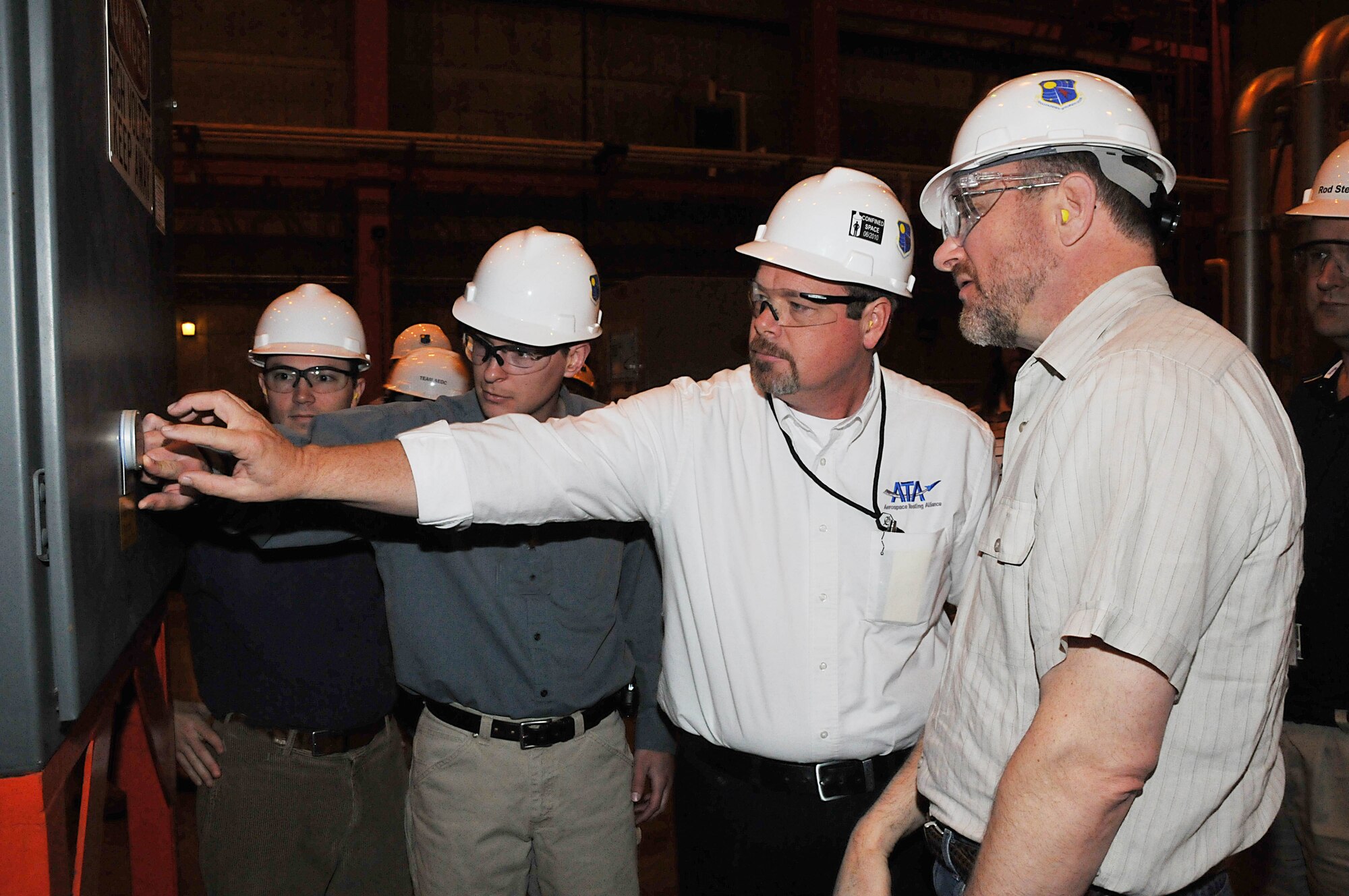 From right, Bill Breznau, from Jacobs Technology, looks on as Walt Bishop, ATA mechanical systems engineering manager, shows Breznau and Robert Shaffer, a Tinker AFB reliability engineer and Josh Segerstrom, Jacobs Technology, and other visitors from Tinker AFB, a new infrared window to provide a safe and less costly way to check on switch gear at the Aeropropulsion Systems Test Facility’s air side. (Photo by David Housch)