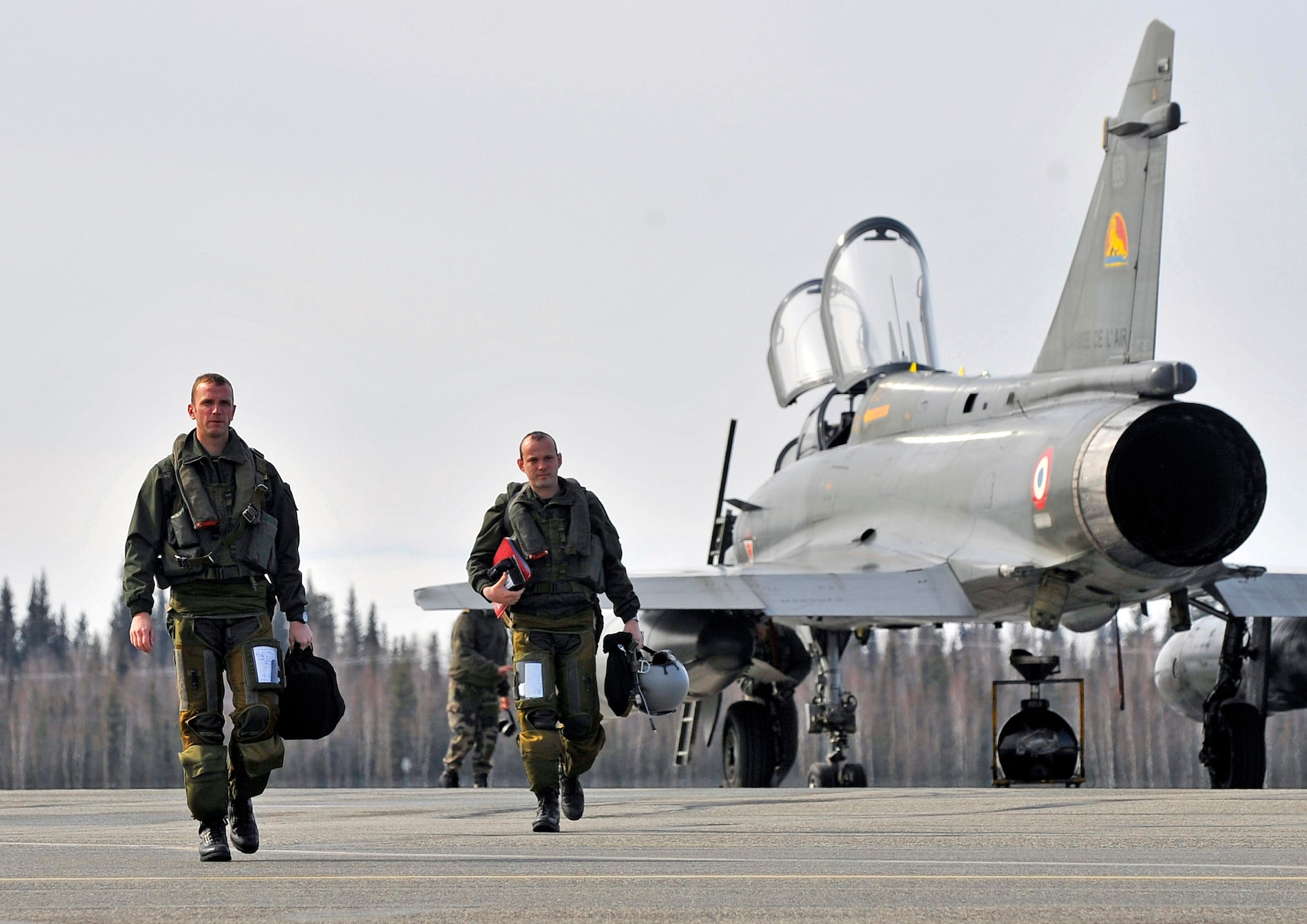 Two fighter pilots from Luxeuil Air Base, France, walk off the tarmac at Eielson Air Force Base, Alaska, April 14.  French air force members arrived at Eielson AFB to participate in Red Flag-Alaska, a military exercise conducted on the Joint Pacific Alaska Range Complex enabling the military to have the largest air-ground training area in the United States. (U.S. Air Force photo/Airman 1st Class Willard E. Grande II)