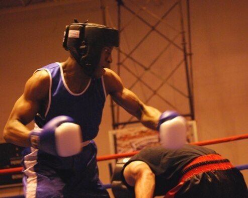 Senior Airman Jerome Thames, 325th Security Forces Squadron desk sergeant, delivers a punch at Alex Fesel, during a fight in the Air Force Boxing Championship held in Lackland Air Force Base, Texas, April 3.  Airman Thames walked away with a silver medal in the 141-pound weight class.  (Courtesy photo)