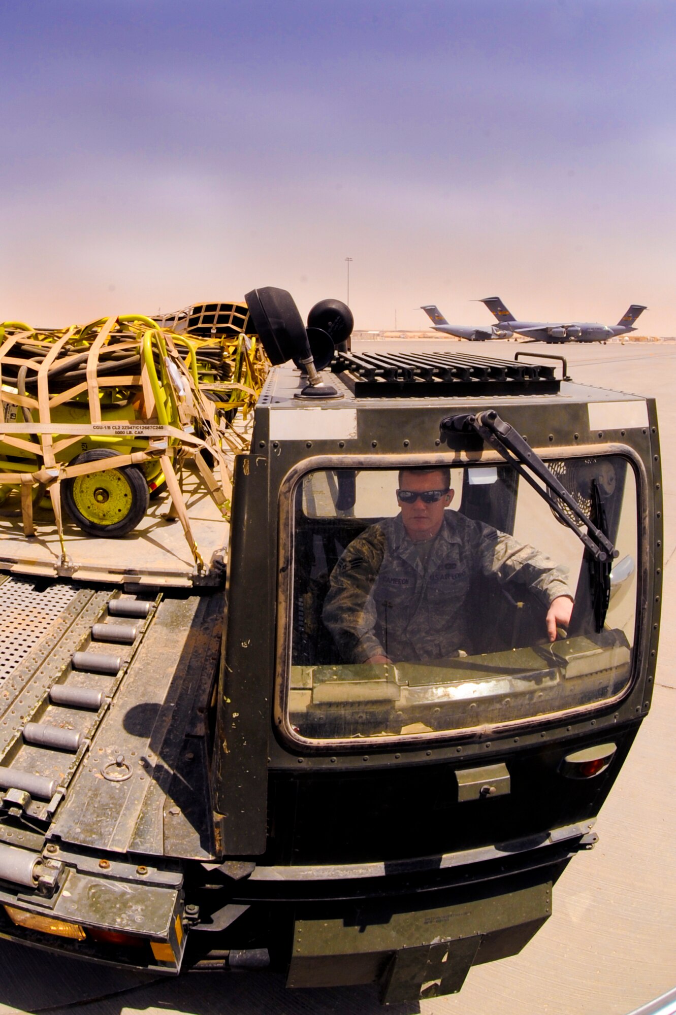 Senior Airman Danny Cameron, an air transporter with the 8th Expeditionary Air Mobility Squadron, drives a 60K Tunner away from a C-17 Globemaster III after offloading its cargo, April 15, 2009, in an undisclosed location in Southwest Asia.  The cargo is stored temporarily on base for distribution to a location in the U.S. Central Command's area of responsibility.  Airman Cameron is native to Dade County, Ga. and is deployed from Pope Air Force Base, N.C. in support of Iraqi and Enduring Freedom and Combined Joint Task Force - Horn of Africa.  (U.S. Air Force Photo by Staff Sgt. Joshua Garcia/released)