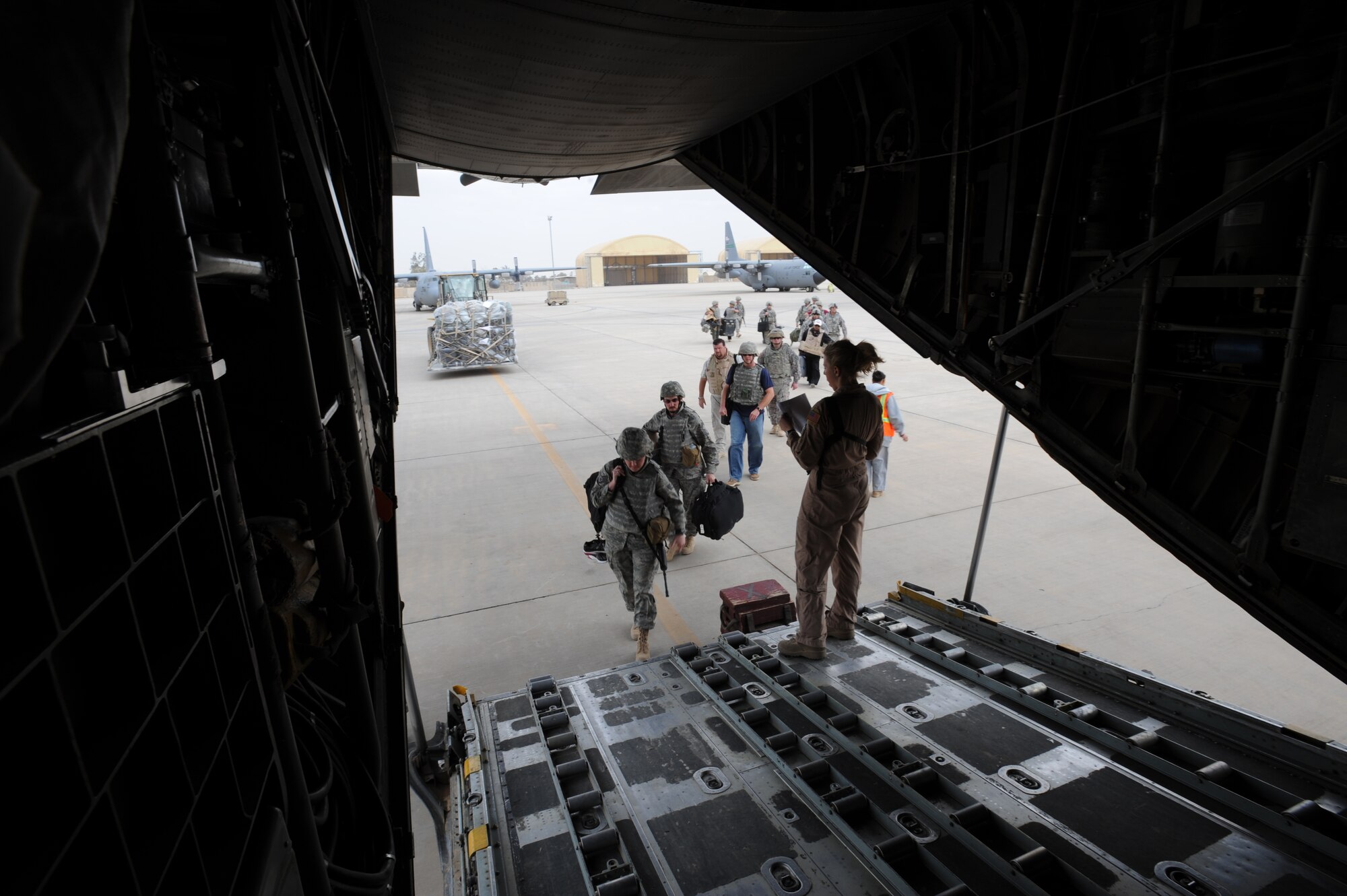 U.S. Air Force C-130 Hercules Loadmaster Airman 1st Class Lauren Lee, assigned to the 777th Expeditionary Airlift Squadron, Joint Base Balad, Iraq, directs passengers during airlift operations April 8, 2009, in support of Operation Iraqi Freedom.  (U.S. Air Force photo by Staff Sgt. James L. Harper Jr.)