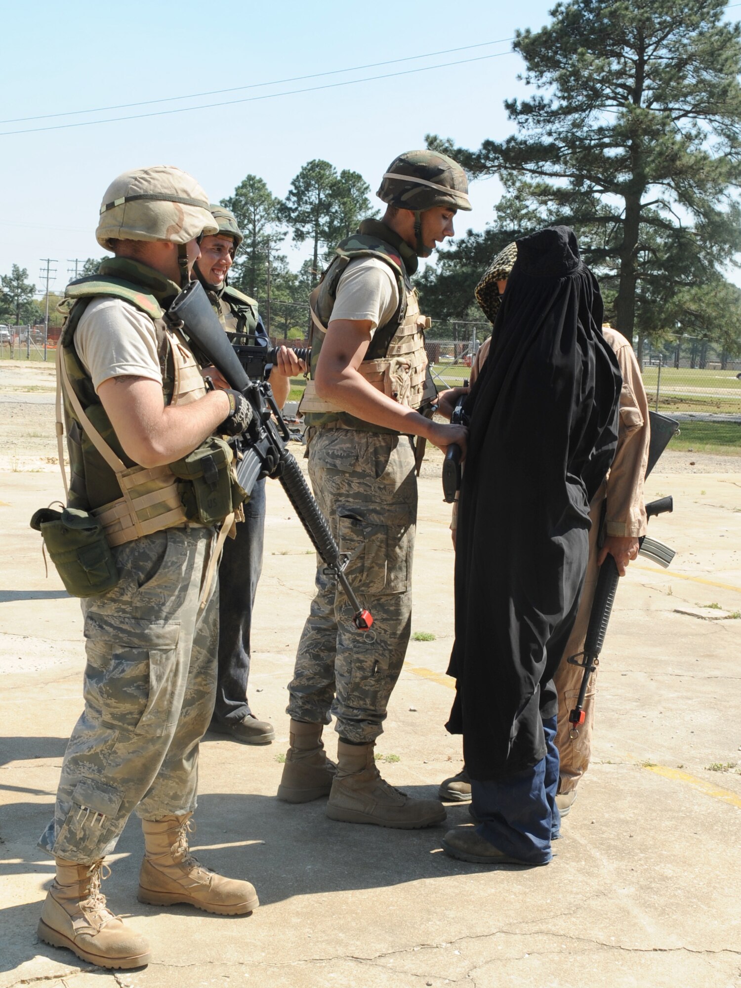 Airman 1st Class Ron Simons and Staff Sgt. Ruben Deleon, both from 336th Aircaft Maintenance Unit, help Airman 1st Class Dereck Reeves, 4th Maintenance Operations Squardon, remove simulated insurgents from the training grounds at Seymour Johnson Air Force Base, N.C., April 9, 2009. Escorting simulated insurgents off the base helps maintain U.S. service member safety. (U.S. Air Force photo by Airman 1st Class Whitney S. Lambert)