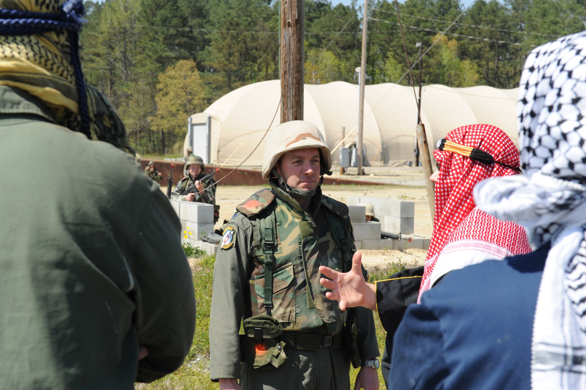 Lieutenant Col. Michael Eltz, 336th Fighter Squadron, listens as an Expeditionary Combat Skills Training instructor, role playing as an insurgent, offers Airmen extra assistance on the training grounds at Seymour Johnson Air Force Base, N.C., April 9, 2009. The simulated insurgents offer to work and help keep the peace in the local community. (U.S. Air Force photo by Airman 1st Class Whitney S. Lambert)