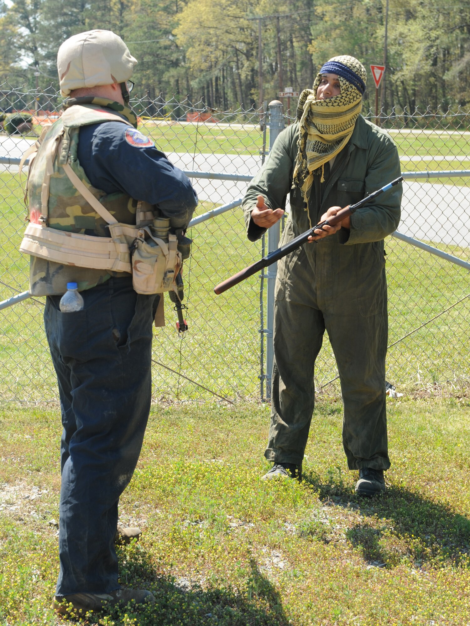 Staff Sgt. Josh Nicholson, 4th Maintenance Operations Squadron, negotiates with mock insurgent Senior Airman Omar Lewis, 4th Equipment Maintenance Squadron, to trade a rifle for water on the training grounds at Seymour Johnson Air Force Base, N.C., April 9, 2009. ECST provides Airmen the skills necessary to survive in life or death situations. (U.S. Air Force photo by Airman 1st Class Whitney S. Lambert)