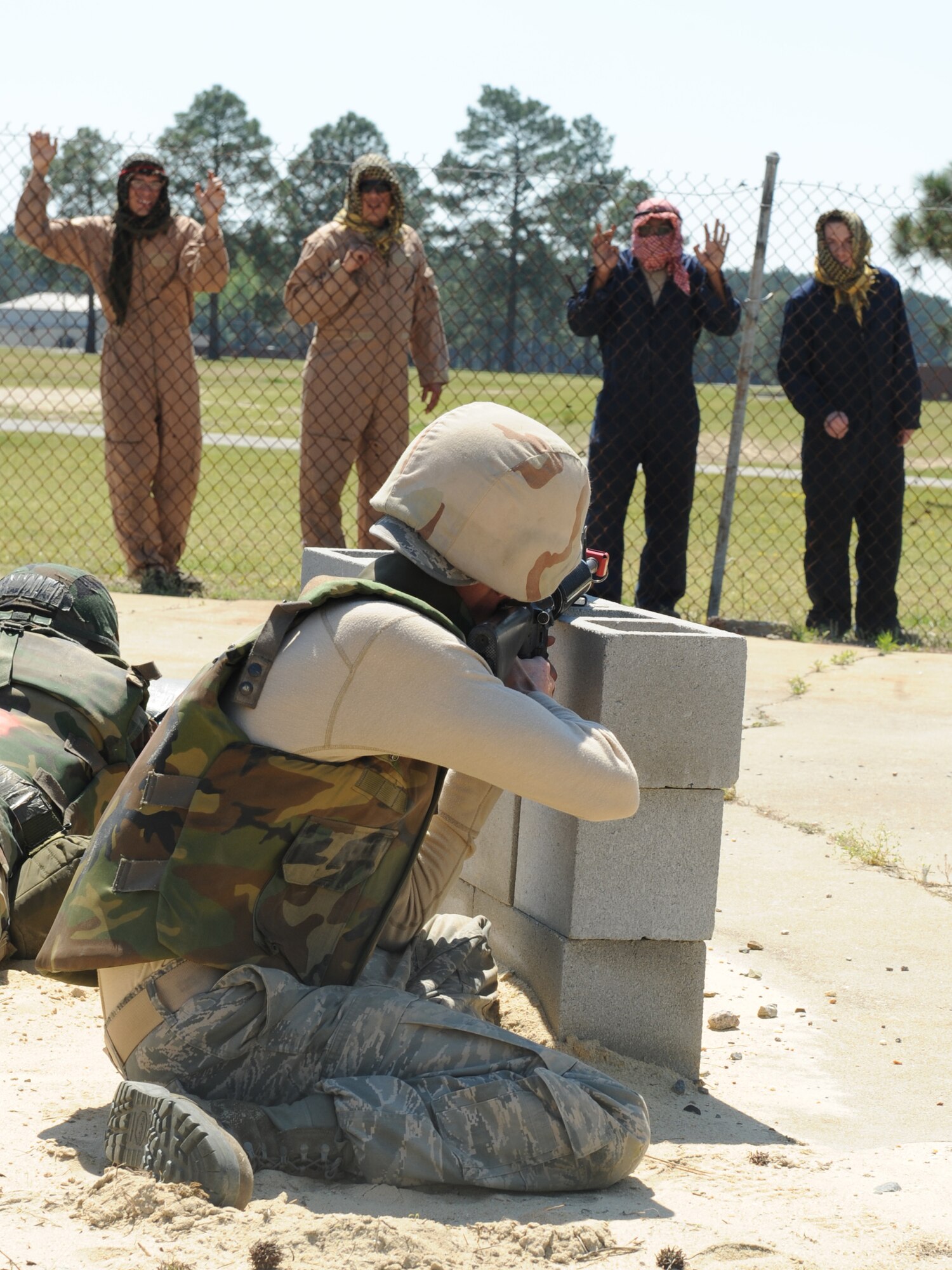 An Expeditionary Combat Skills Training student takes control of Airmen role playing as insurgents on the training grounds at Seymour Johnson Air Force Base, N.C., April 9, 2009. ECST teaches Airman effective negotiating skills by using the S-A-L-U-T-E report. Air Force members use the S-A-L-U-T-E report to communicate enemy attack information up the chain of command. (U.S. Air Force photo by Airman 1st Class Whitney S. Lambert) 