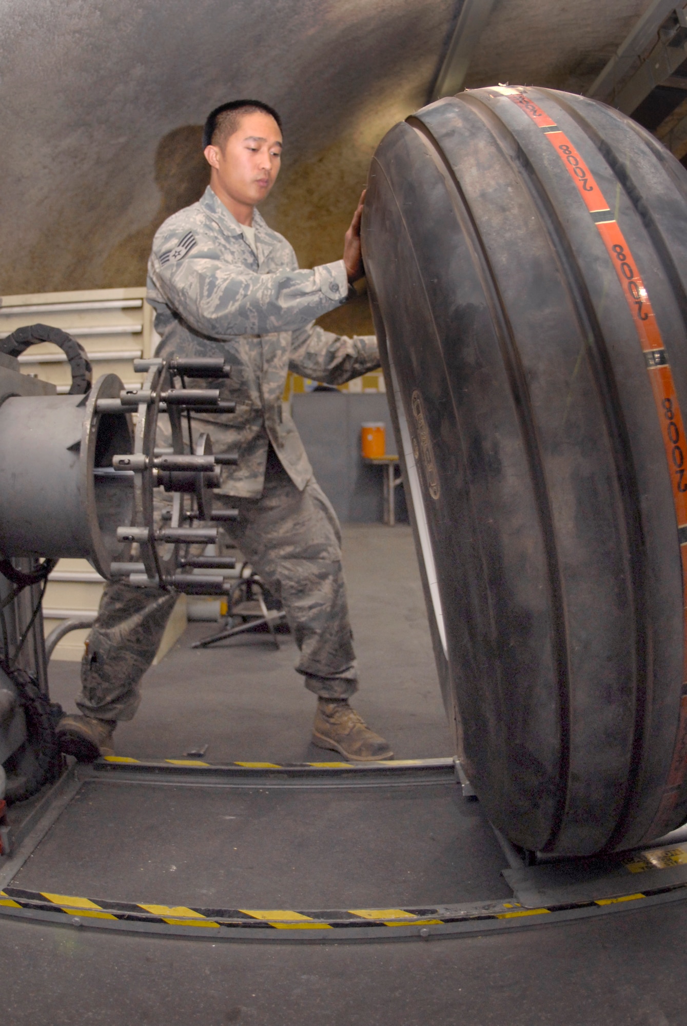 Staff Sgt. Ruben Ramones, 379th Expeditionary Maintenance Squadron wheel and tire shift lead, rolls a C-130 tire to the air filling station after assembling the main wheel components, Apr. 13, 2009, at an undisclosed location in Southwest Asia.  The base Wheel and Tire shop supports eight forward operating locations and seven different types of aircraft with a full range of wheel and tire services.  Sergeant Ramones hails from Sacramento, Calif. and is deployed from Yokota Air Base, Japan in support of Operations Iraqi and Enduring Freedom and Combined Joint Task Force - Horn of Africa.  (U.S. Air Force photo/Senior Airman Andrew Satran/released)    