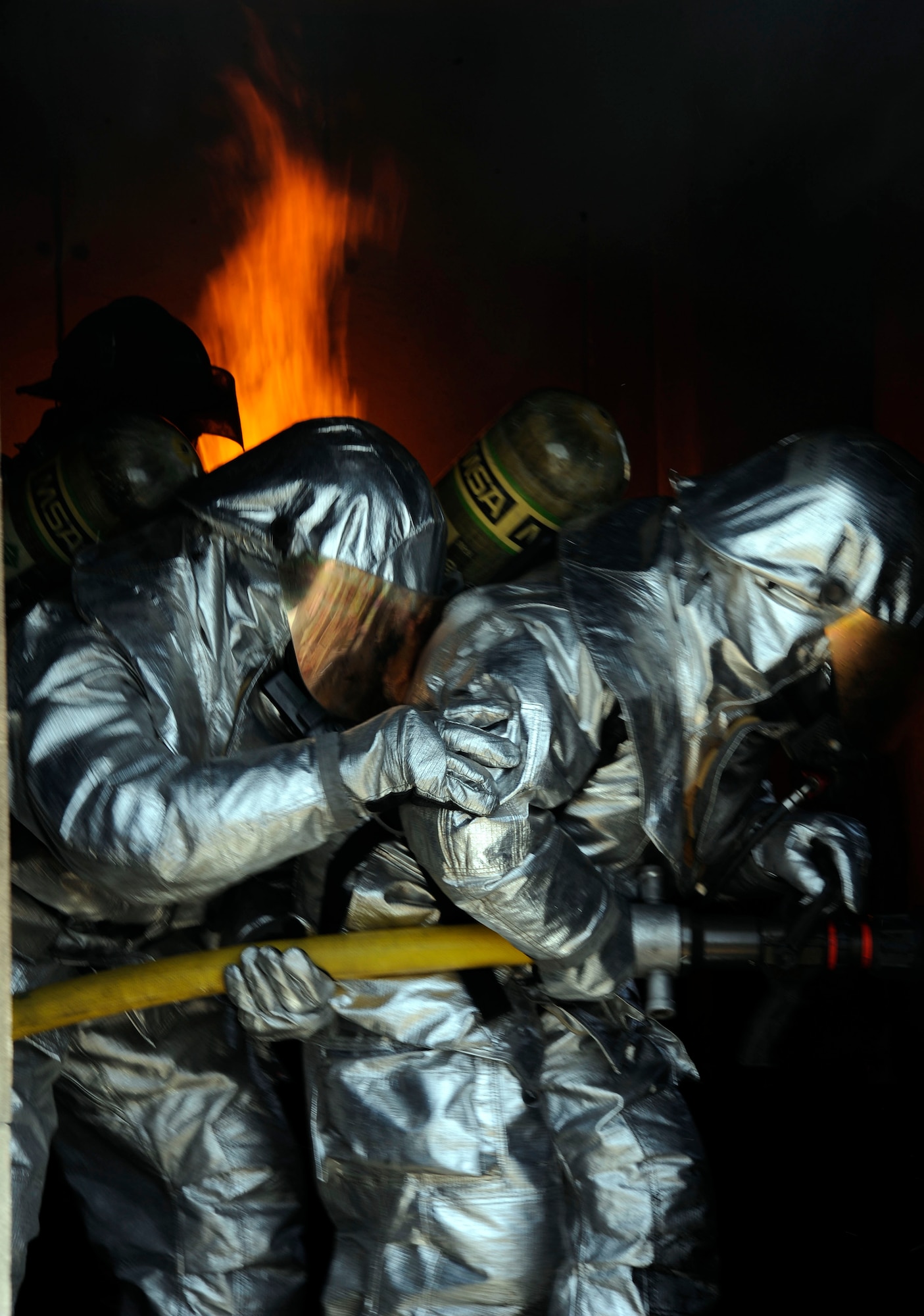 Members of the Iraqi air force and Iraqi civil defense clear out a room during a live-burn exercise in Baghdad, Iraq April 13, 2009.  The 26 students are learning how to become fire fighters in the Basic Fire Course held at the Joint Fire Academy. The students have to be able to take what they learn in the classroom and perform it in real life scenarios.  Some of the tasks the students have to endure are live-fire training on cars, interior buildings and interior live fires.  (U.S. Air Force photo by Senior Airman Jacqueline Romero)