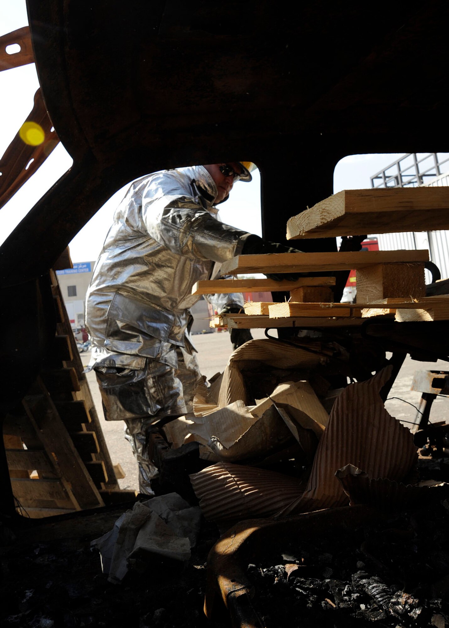 Tech. Sgt. Brian Partido, 821st Basic Technical Training Squadron, Coalition Air Force Transition Team fire rescue advisor, prepares for a scenario by loading pallets in a car as burning material for the Basic Fire Course in Baghdad, Iraq April 11, 2009. Sergeant Partido is making a live burn exercise for the students of the Iraqi Joint Fire Academy. Twenty-six students of the Iraqi air force and the Iraqi civil defense applied what they learned in the classroom. Sergeant Partido is deployed from the 19th Civil Engineer Squadron at Little Rock Air Force Base, Ark., and is a native of El Paso, Texas.  (U.S. Air Force photo by Senior Airman Jacqueline Romero)