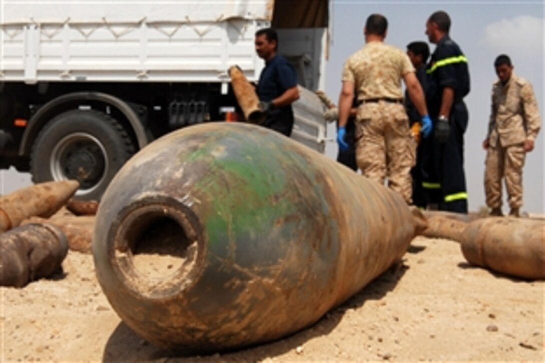 Iraqi soldiers and policemen unload one of four trucks carrying nearly 8,000 lbs. of munitions to be destroyed in the desert outside of Karbala, Iraq, April 4, 2009. The mortar rounds, missles and rockets confiscated from throughout Babel province have been accumulating at checkpoints and headquarters buildings. Iraqi forces worked with U.S. Army soldiers assigned to the 760th Explosive Ordnance Disposal Company to dispose of the munitions. 