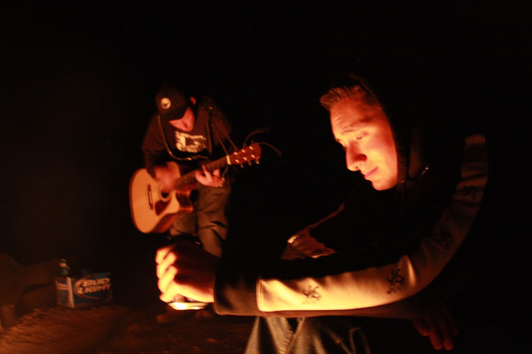 Lance Cpl. Aaron Kristopik, a paralegal clerk with the Combat Center’s Staff Judge Advocate and a native of New Britain, Conn., relaxes by the fire as friends play the guitar and sing in the middle of the Mojave National Preserve April 18 night.