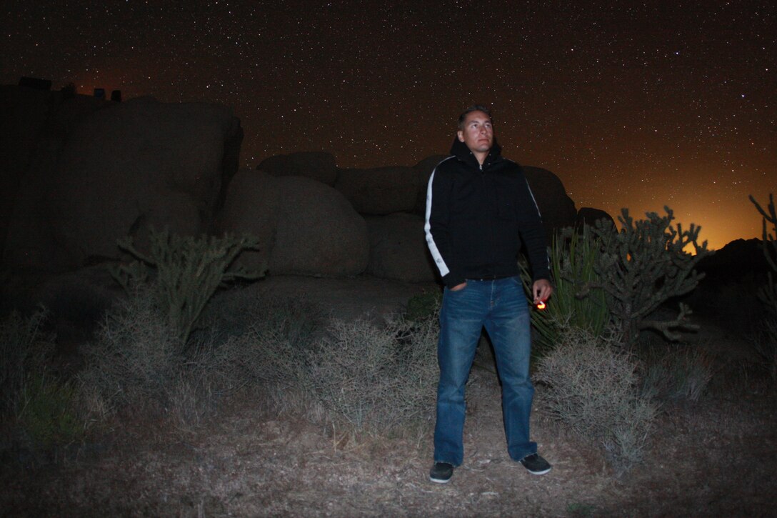 Lance Cpl. Aaron Kristopik, a paralegal clerk with the Combat Center’s Staff Judge Advocate and a native of New Britain, Conn., surveys the clear skies April 18 night in the Mojave National Preserve as his friends cook over the fire in the background.