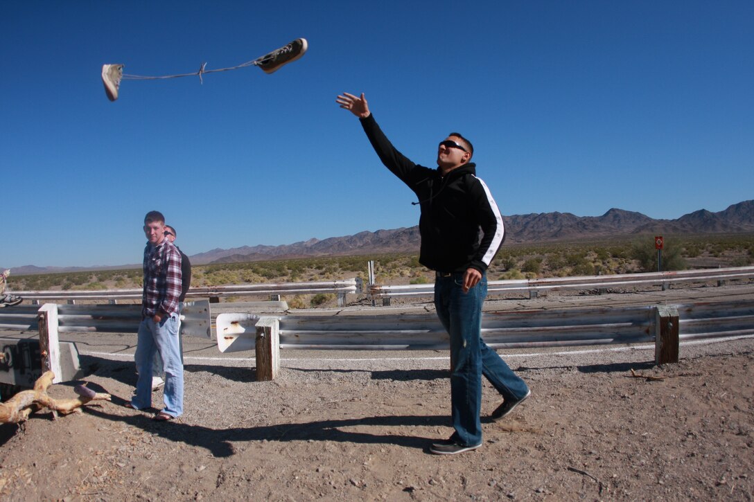 Lance Cpl. Aaron Kristopik, a paralegal clerk with the Combat Center’s Staff Judge Advocate and a native of New Britain, Conn., throws shoes into the infamous ‘shoe tree’ outside of Amboy, Calif., on the way out to the Mojave National Preserve April 18.