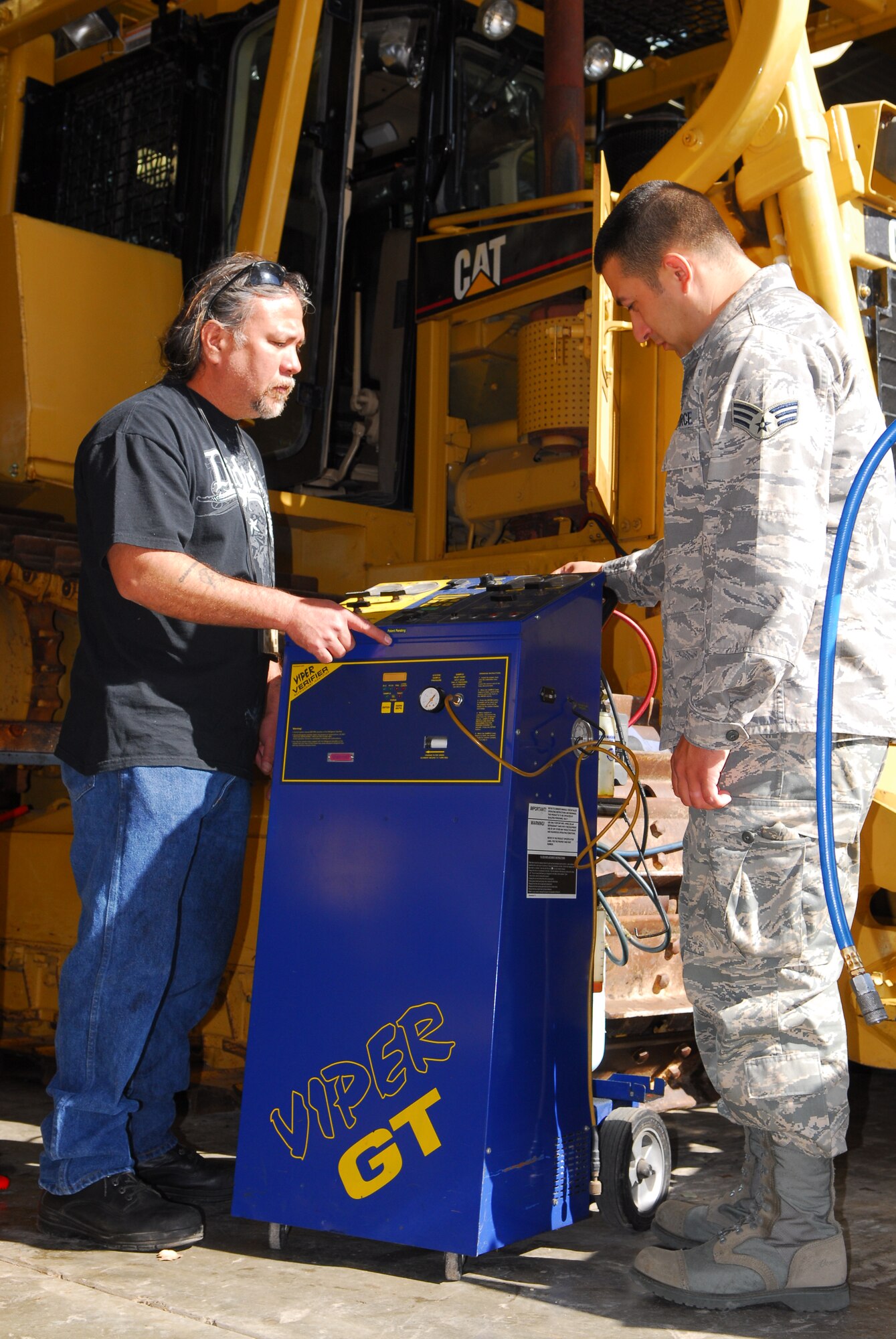 VANDENBERG AIR FORCE BASE, Calif. -- Tom Barcinas, a 30th Logistical Readiness Squadron heavy vehicle mechanic, teaches Senior Airman Arturo Vega, a 30th LRS heavy vehicle mechanic, how to operate an air conditioning recharging unit here April 16. Air conditioning units are a vital part of the bulldozers the 30th Civil Engineer Squadron uses to prevent the spread of wildfires. (U.S. Air Force photo/Airman 1st Class Steve Bauer)