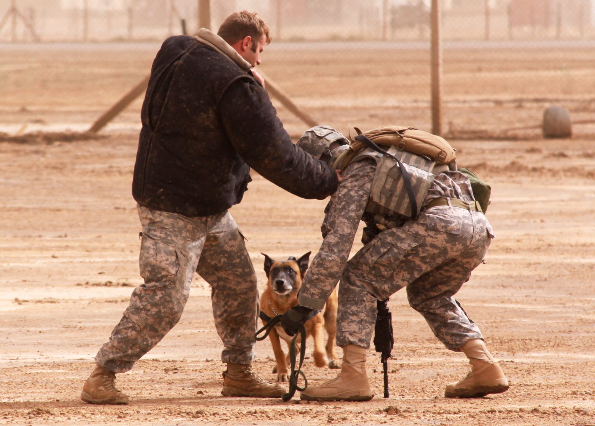 Military working dog Robby charges a simulated aggressor to protect his handler, Senior Airman William Bailey, during a training session at Camp Taji, Iraq. Airman Bailey is a  Joint Expeditionary Tasking Airman from the 732nd Air Expeditionary Group attached to the Army's 1st Calvary Division. (U.S. Air Force photo/Tech. Sgt. Lionel Castellano)