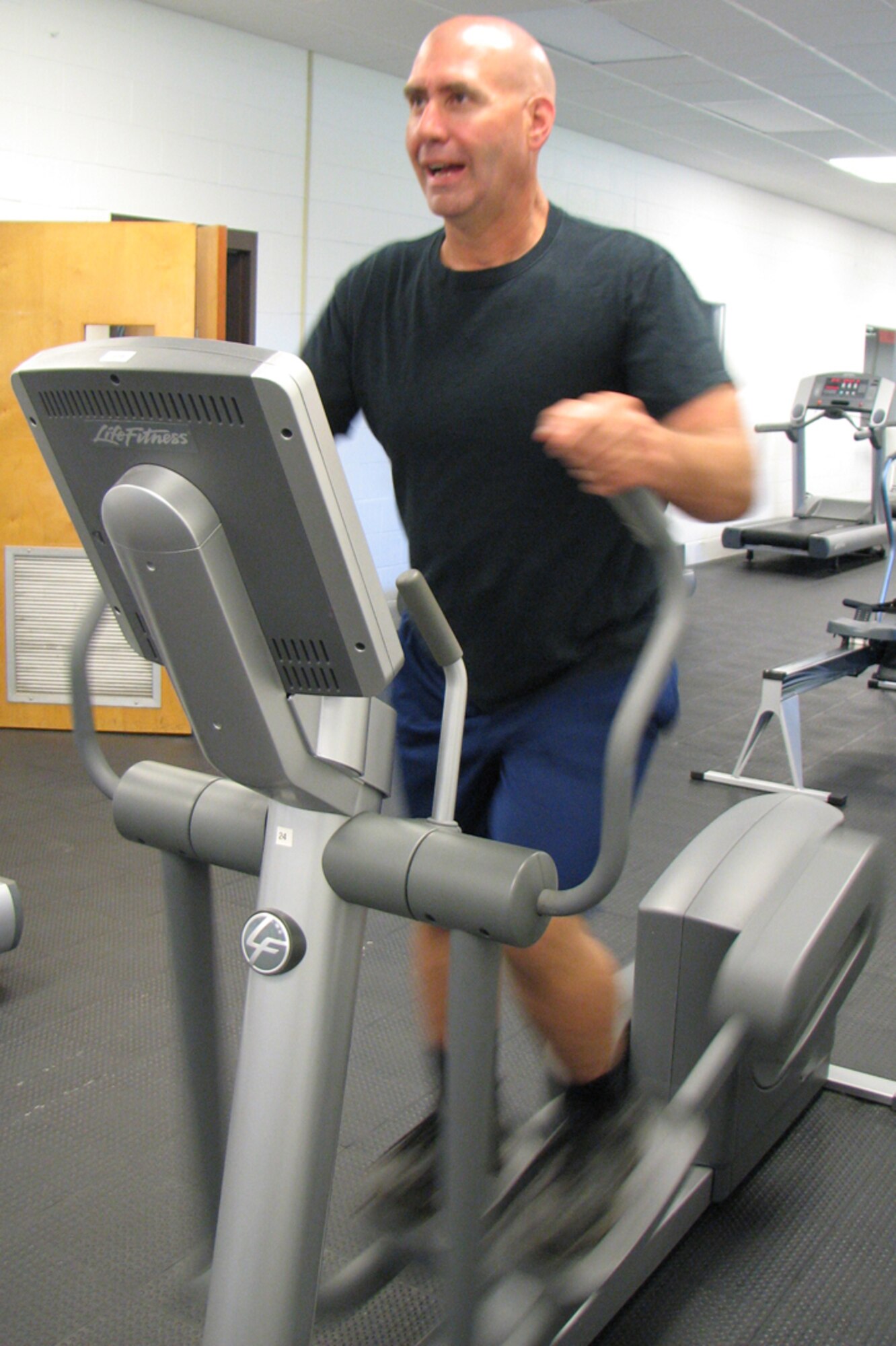 Ken Hemshrot, NEADS Emergency Manager, works out on an elliptical machine at the Fitness Center. He was crowned the “Biggest Loser” after dropping 51 pounds which represented a total percent weight loss of 20 percent (Photo by Maj. Leo Devine). 