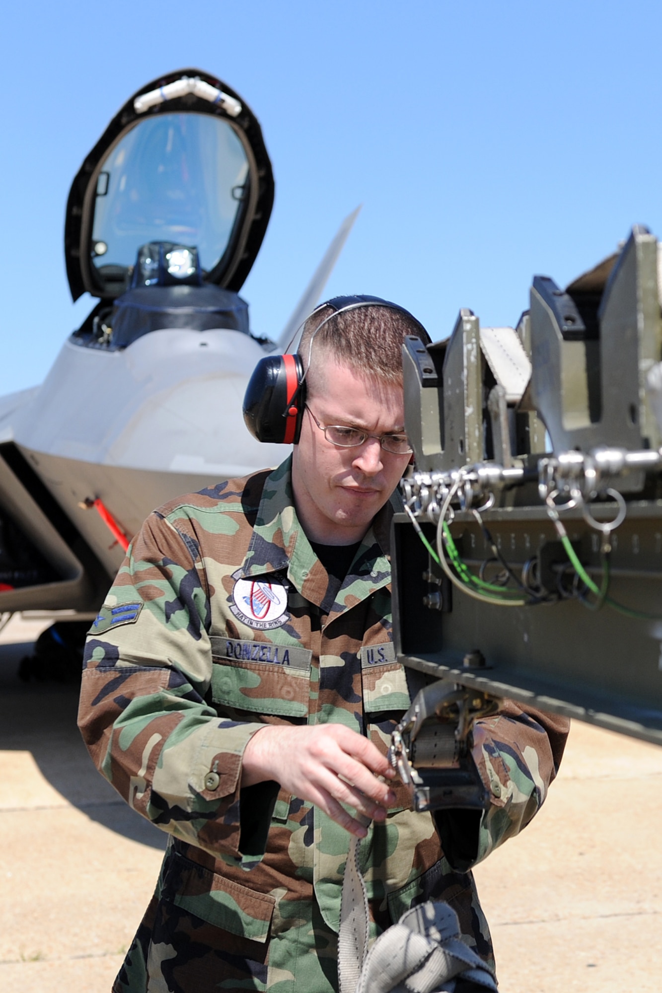 LANGLEY AIR FORCE BASE, Va. – Airman 1st Class Derek Donzella, 94th Aircraft Maintenance Unit weapons load crew member unties a strap while preparing to load a missile to a F-22A Raptor here April 17. Squadron Airmen are judged quarterly on their accuracy, efficiency and speed. (U.S. Air Force photo/Airman 1st Class Gul Crockett)