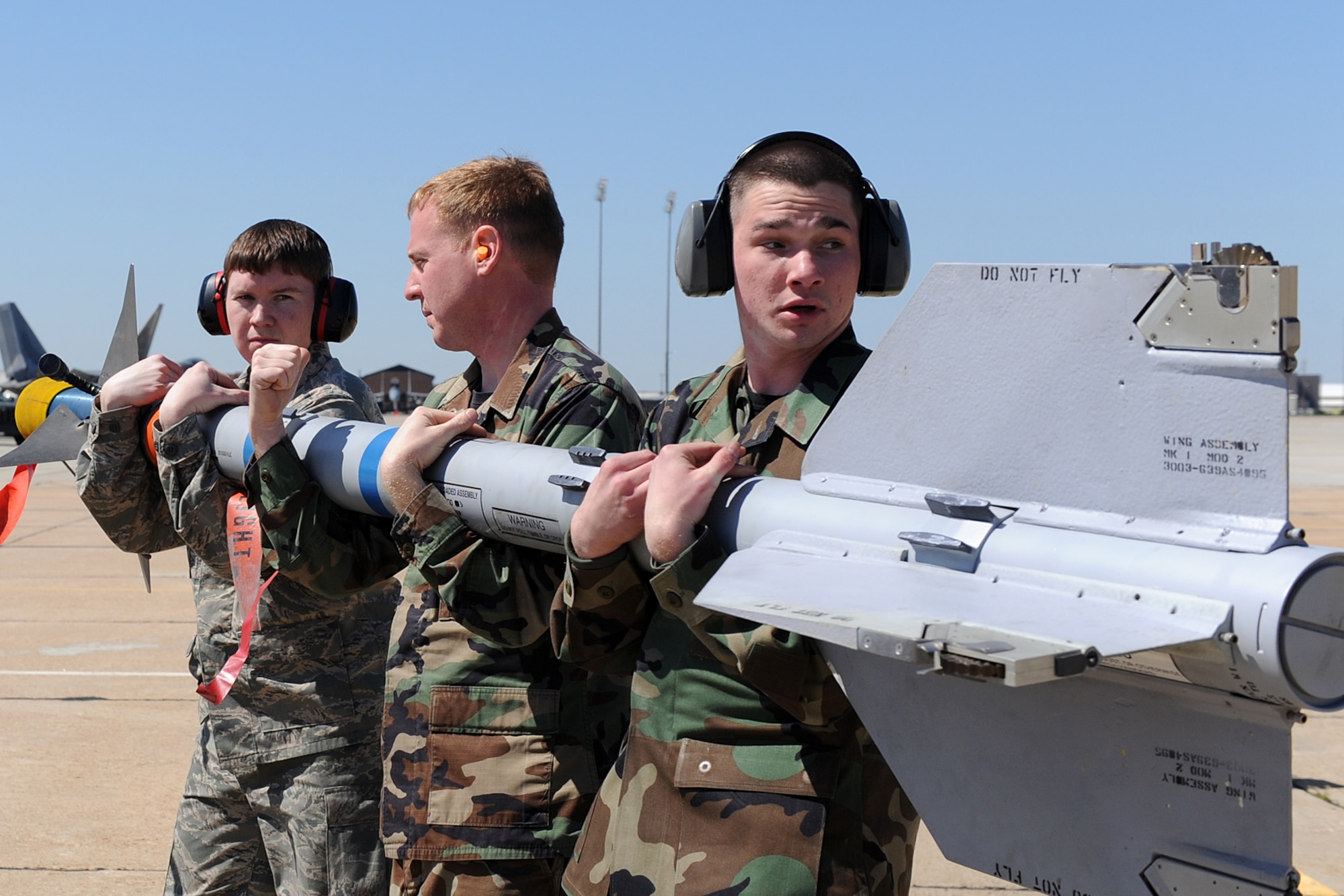 LANGLEY AIR FORCE BASE, Va. – Airman 1st Class Brett Lewis, Staff Sgts. Christopher Stacklin and Nicholas Lanna, 27th Aircraft Maintenance Unit weapons load crew members, load a missile onto a F-22A Raptor during a quarterly load crew competition here April 17. Squadron finalists are judged quarterly on their accuracy, efficiency and speed. (U.S. Air Force photo/Airman 1st Class Gul Crockett)