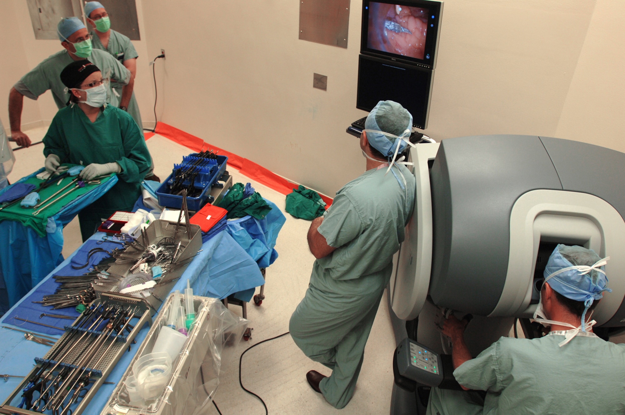 Medical personnel look at a monitor while Lt. Col. (Dr.) Kyle Weld (right) performs a laparoscopic prostatectomy, the surgical removal of prostate cancer, April 10 at Wilford Hall Medical Center. Dr. Weld is the first Air Force doctor to use a robot in surgery, and is the director of endourology at the  59th Surgical Specialties Squadron. The robot provides a magnified, high-definition, three-dimensional view for the physician. (Air Force photo/Senior Airman Nicole Roberts) 