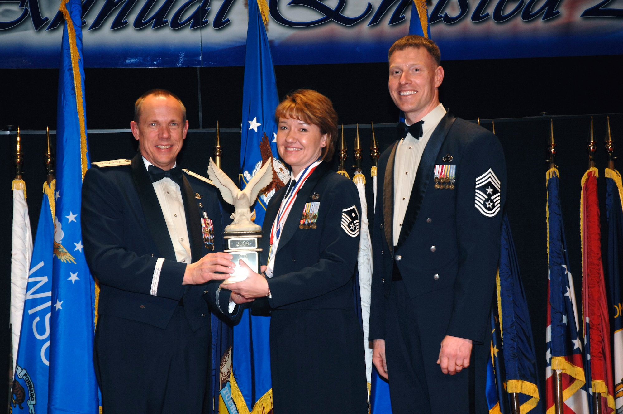 AFMC Commander Gen. Hoffman (left) and AFMC Command Chief Master Sgt. William Gurney present the first sergeant award to Master Sgt. Christina Kibler of the 78th Force Support Squadron at the 2009 Annual Enlisted Awards Banquet. U. S. Air Foce Photo by Al Bright