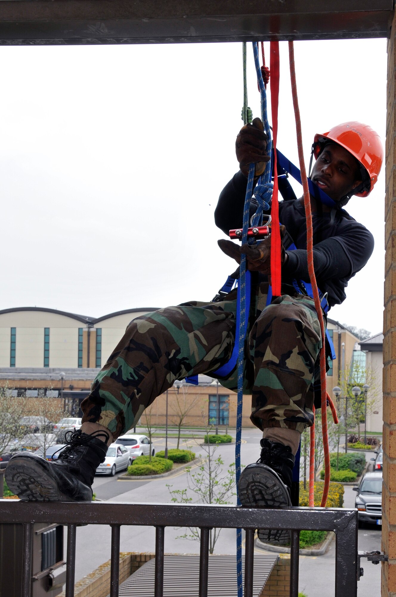 ROYAL AIR FORCE LAKENHEATH -- Airman 1st Class Bruce Bennett, 48th Civil Engineer Squadron firefighter, adjusts his rappel rack during a technical rescue course here April 13, 2009. A rappel rack is an 'U' shaped frame, attached to a rappeler's harness, into which snap multiple bars that pivot from the other side of the frame. The rope is woven through as many of the bars as are required to provide sufficient friction. (U.S. Air Force photo by Airman 1st Class Perry Aston) (Released)
