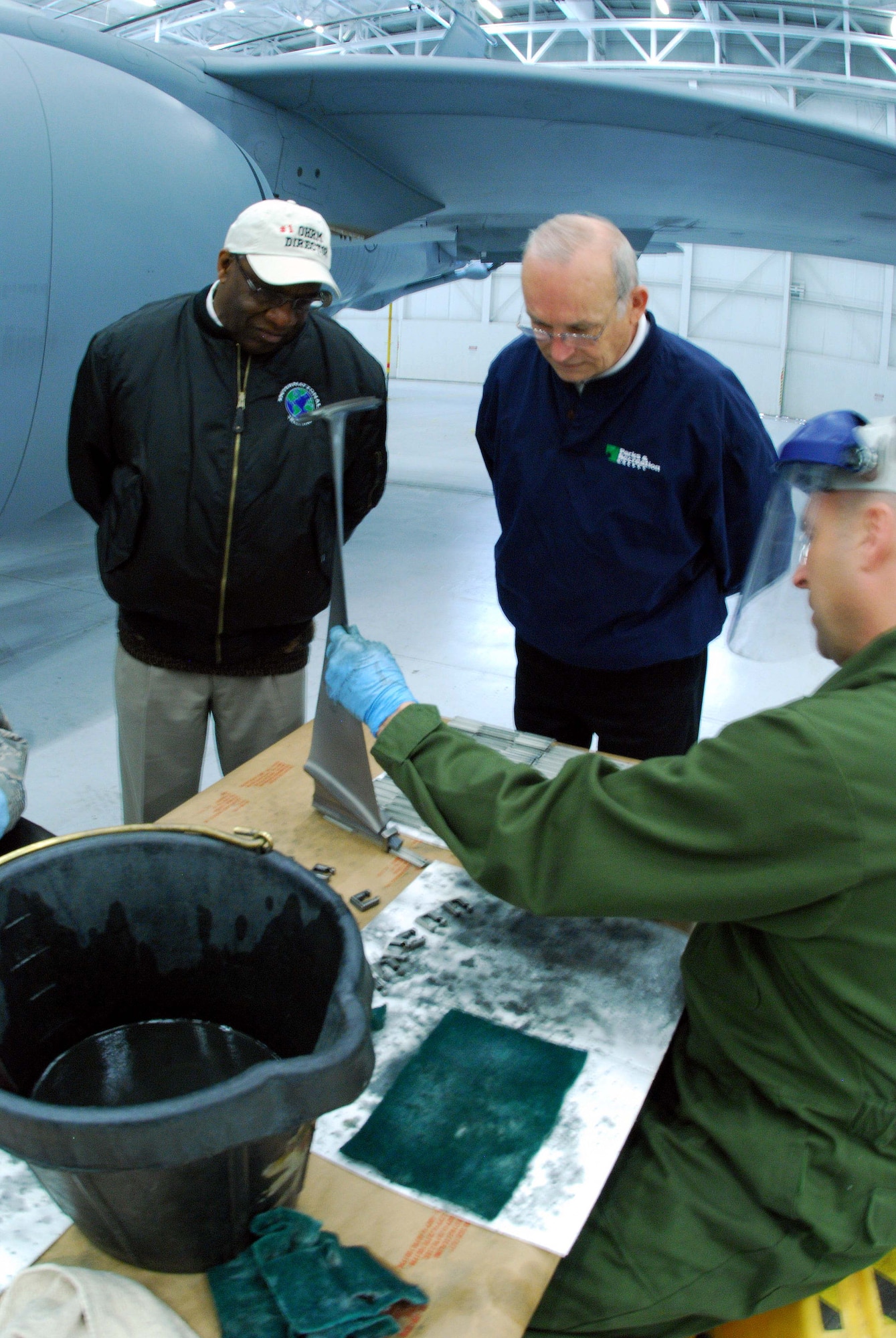 Lee Schiek, 459th Air Refueling Wing honorary commander, and Donald Bridgeman, 459th Mission Support Group honorary commander, observe Tech. Sgt. David Campbell, 459th Maintenance Group jet propulsion mechanic cleans lube off retainers and spacers which is scheduled every 1500 flying hours.  (U.S. Air Force photo/ Senior Airman Ashley Crawford)