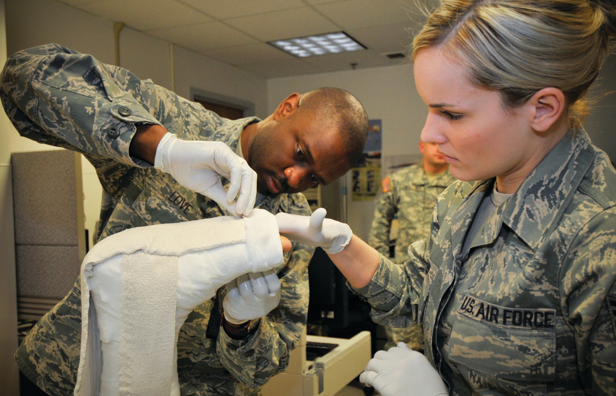 Captain Dexter Love, 779th Medical Surgical Operations Squadron orthopedic surgeon, and Staff Sgt. Christine Keller, 779 MSOS orthopedic medical technician, apply a pre-operative compression splint to a patient at Malcolm Grow Medical Center recently. (U.S. Air Force photo/ Tech. Sgt. Suzanne M. Day)