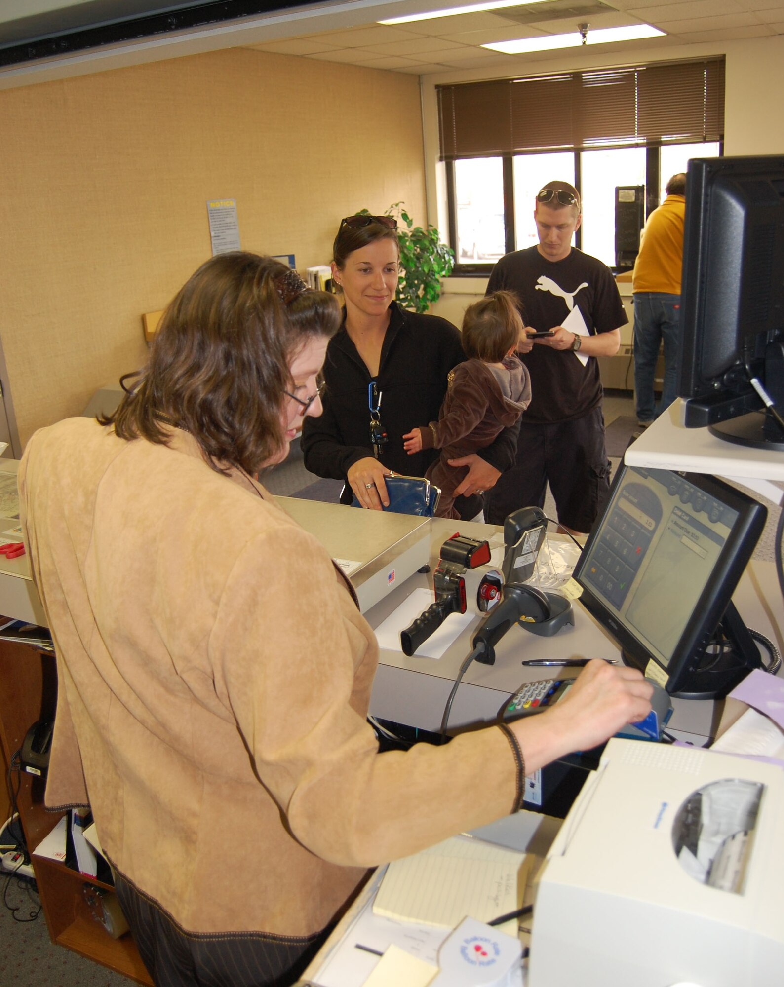 Barb Overton, the new Malmstrom postal clerk, assists a customer at the base post office April 13. The base acquired a new postal contract April 1. People are invited to their “open house” April 23 from noon to 3 p.m. to meet the new staff members and enjoy snacks and refreshments. (U.S. Air Force photo/Staff Sgt. Eydie Sakura)